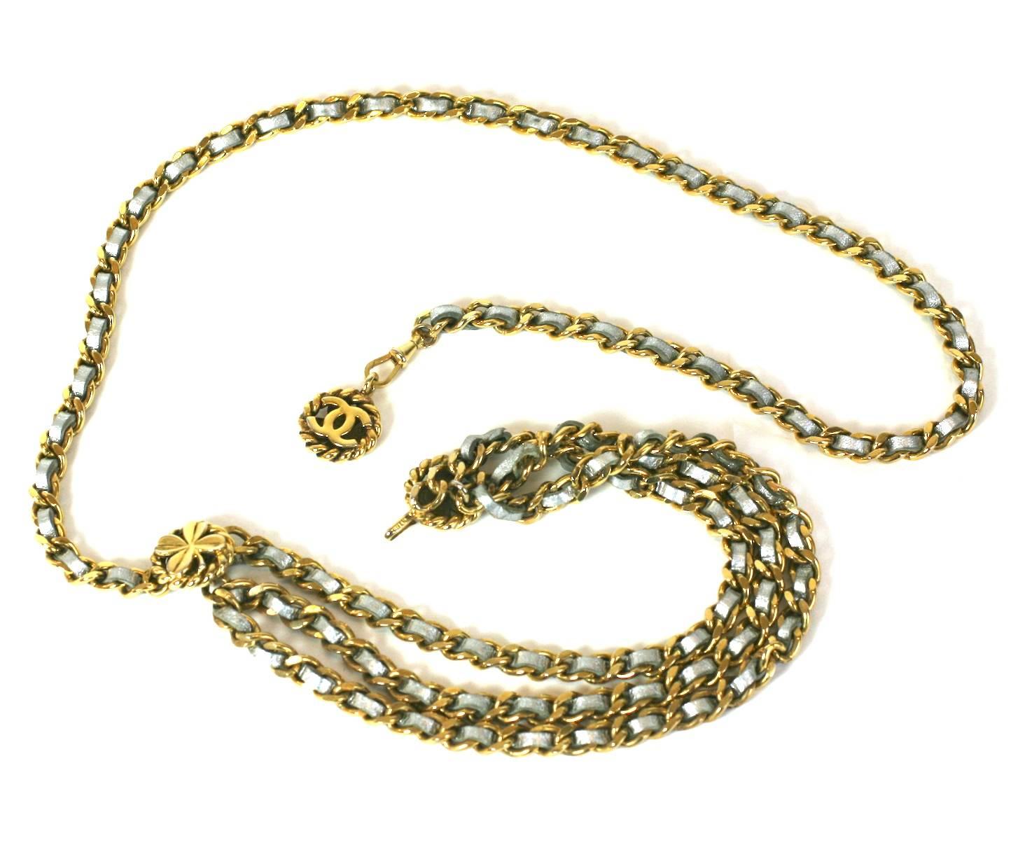 Chanel silver kid and gilt metal swag belt. Signature style with 3 chains in front. The addition of the silver leather threaded through the chain updates this iconic style. Clover charms on belt and a reversible fob at end with 