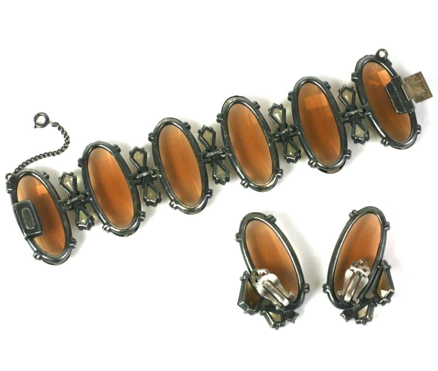 Elsa Schiaparelli's massive bracelet and ear clips of large smokey topaz top facet crystals with citrine and Aurora Swarovski crystal spacers. Extremely striking combination of colors and scale, set into antique silvered metal. 1950's USA,