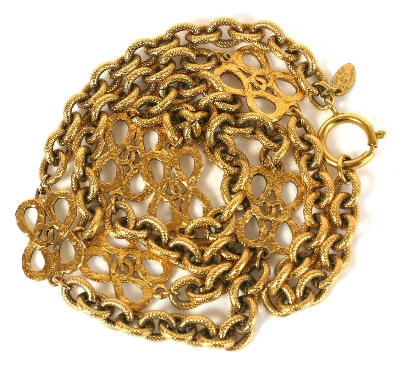 Elegante catena Chanel con logo in oro martellato a 6 stazioni. Ogni stazione è una doppia figura a 8 con la scritta 