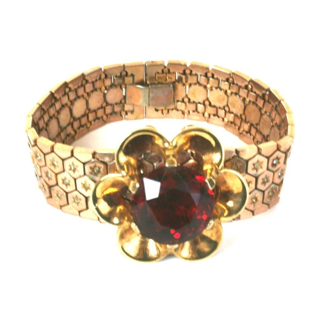 Trifari Retro Style flexible honeycombed rose gold plated and crystal pave link bracelet. Its focal large faux faceted ruby stone is prong set in a retro floriform removeable clip brooch.  A novelty jewelry design of the period. Excellent Condition.