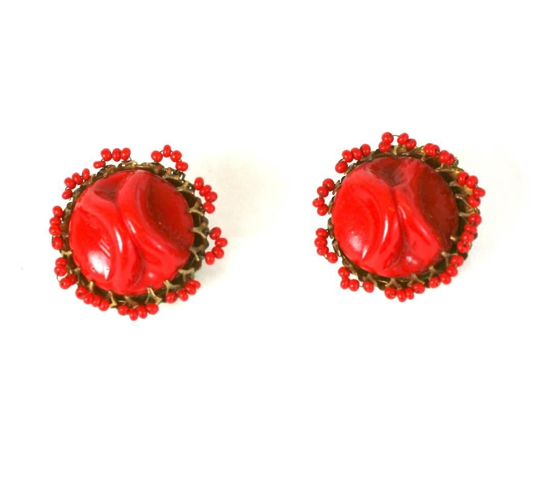 Miriam Haskell Clips d'oreille en pate de verre rouge pincée, sertis dans un filigrane doré Signature et agrémentés de perles de rocaille rouges.
Raccords à clip. états-Unis des années 1950. Excellent état.
Diamètre 1 1/8