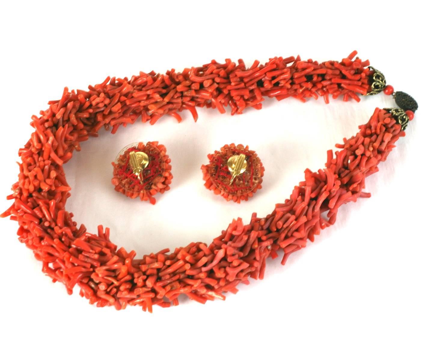 Wonderful Branch Coral Suite composing rope necklace sewn with hundreds of branch coral pieces to form a tubular coral necklace. Coral branch pieces are also sewn onto a backing to form clip button earrings. 
The necklace has bronze toned filigree