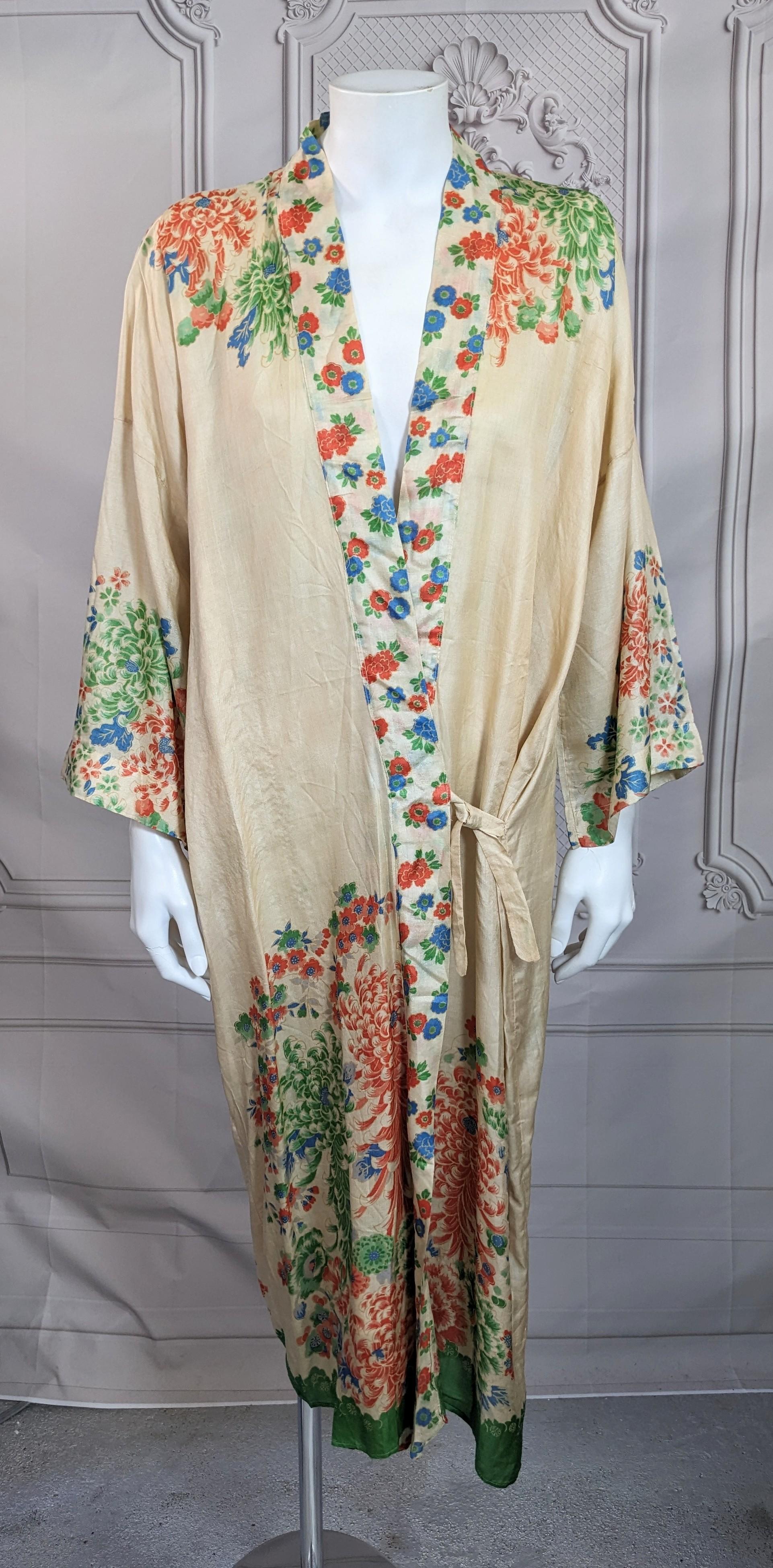 Delizioso kimono da salotto in seta Art Deco di manifattura giapponese per il mercato occidentale degli anni '20. Il fondo in seta naturale marrone è stampato in modo insolito in verde, arancione e blu, imitando la pittura serigrafica giapponese.
