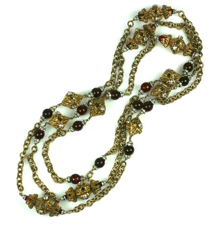 Chanel's signature baroque, gilt metal filigree, ruby pate de verre and crystal rondelle sautoir necklace from 1950's. A staple of the Chanel language, produced by Robert Goossens and worn with Chanel's classic suits or evening clothes. Unsigned.