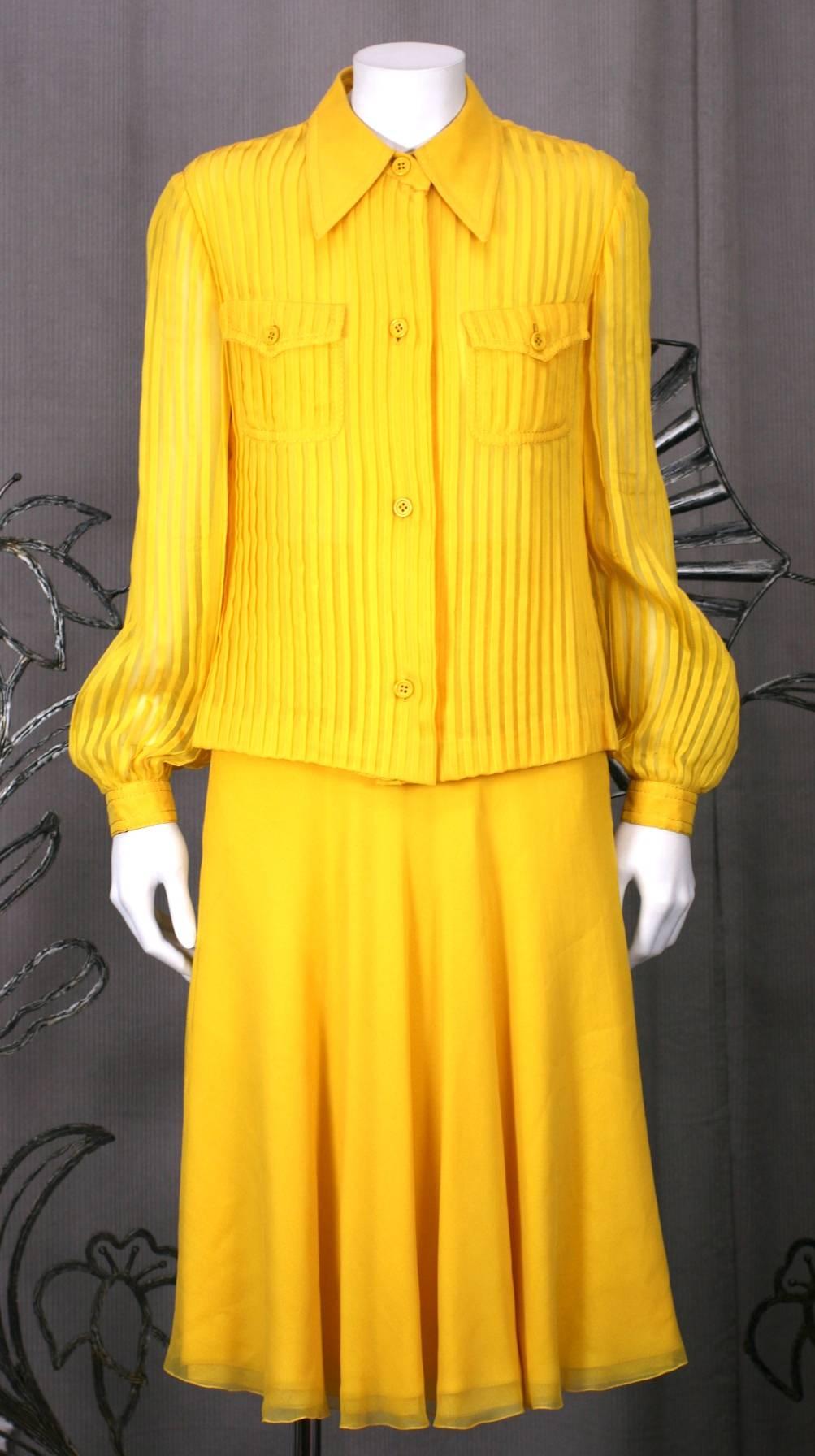 Galanos' Charming Chrome Yellow silk chiffon set with pin tucked shirt and 5 ply chiffon bias cut skirt. Blouse is completely pin tucked with 2 chest pockets and heavy silk top stitching. The top stitching is also repeated on the waist band of the