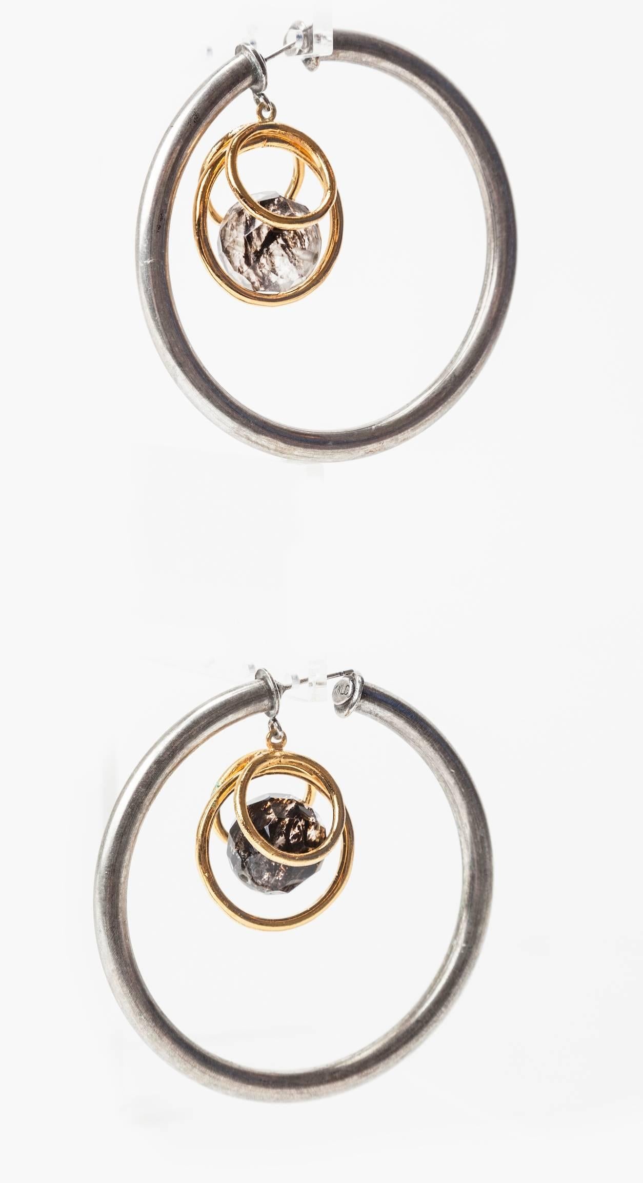 Oversized Orbit Hoop earrings in silver toned metal, suspending a faceted rutilated quartz bead in gilt hoop settings. 
Made in Parisian studios of Mark Walsh Leslie Chin. 21 Century.
Excellent condition. Hoop 2.75