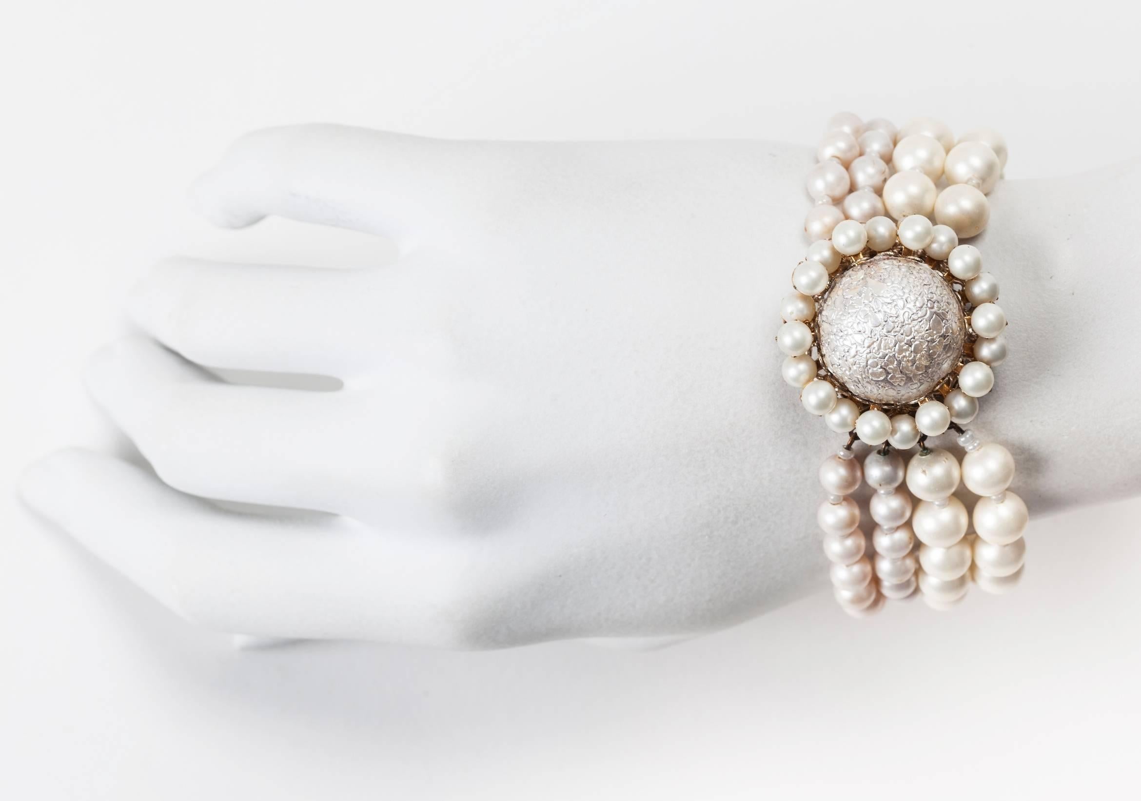Miriam Haskell signature freshwater faux pearl and rare textured pearl floriform clasp, four strand bracelet. Set in signature Russian gilt. 1950's USA. Excellent condition.

Length 7.75