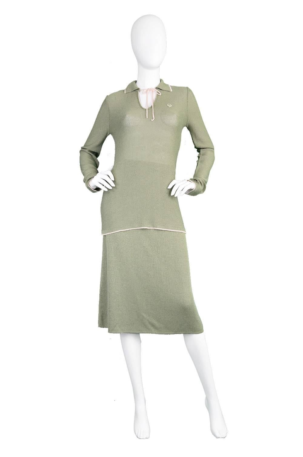 A stunning vintage women's two piece skirt suit from the 1970s in a green knit fabric with a salmon coloured trim to the collar and a delicate bow that ties at the front, creating a flirty keyhole. 

Made in Italy, this high quality suit's