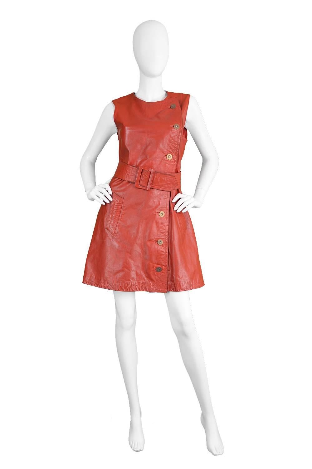An incredible and rare vintage women's dress from the early 1970s by genius and highly collectible British designer, Jean Muir for Morel of London. Still so current, this dress is in a supple red leather with an asymmetrical button fastening and a