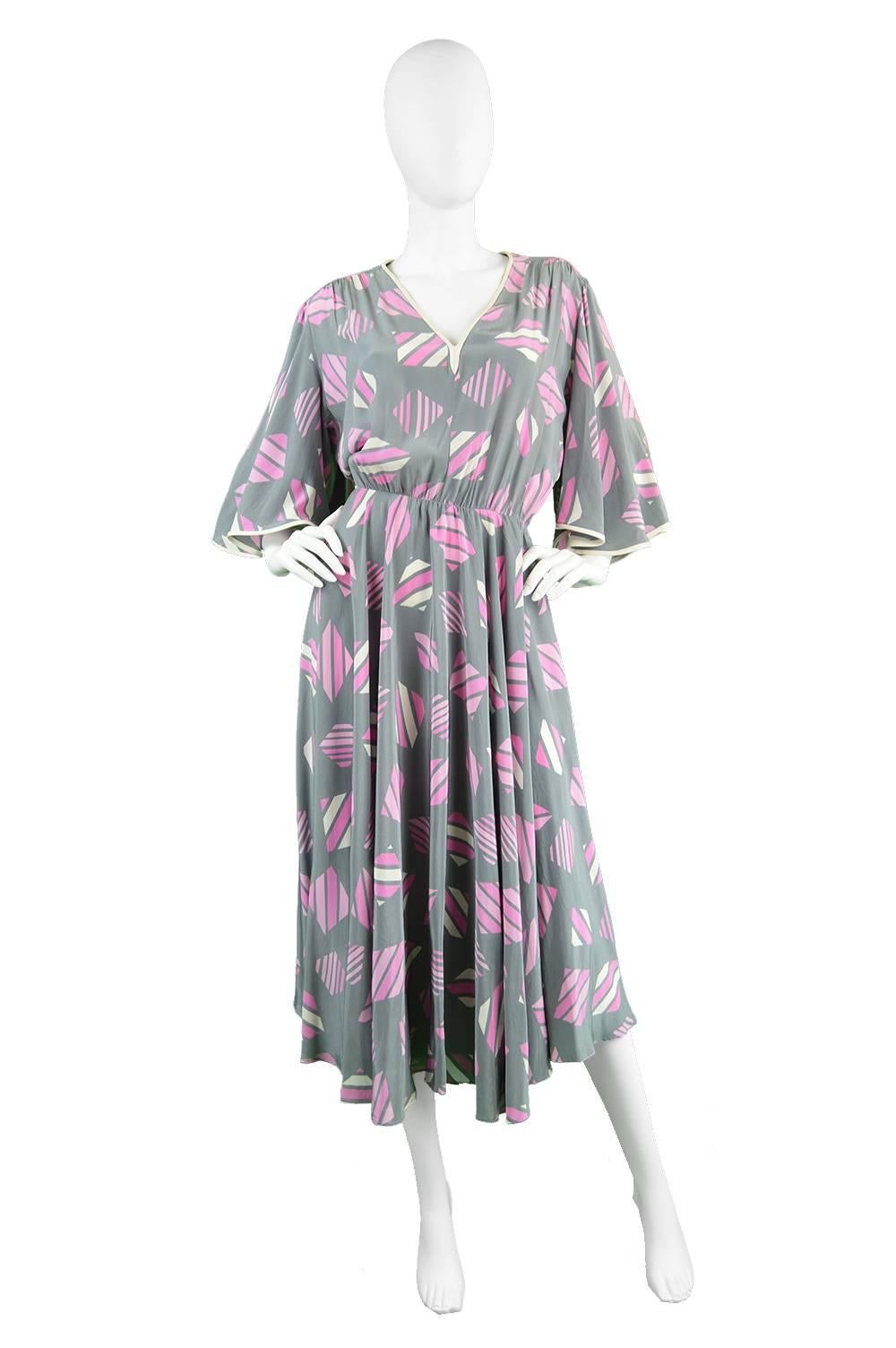 A stunning and incredibly elegant vintage dress from the 1980's by legendary luxury fashion house, Balenciaga. In a light and airy grey silk fabric with a pink abstract print throughout. 

In a flattering silhouette that is loose and blousy on top