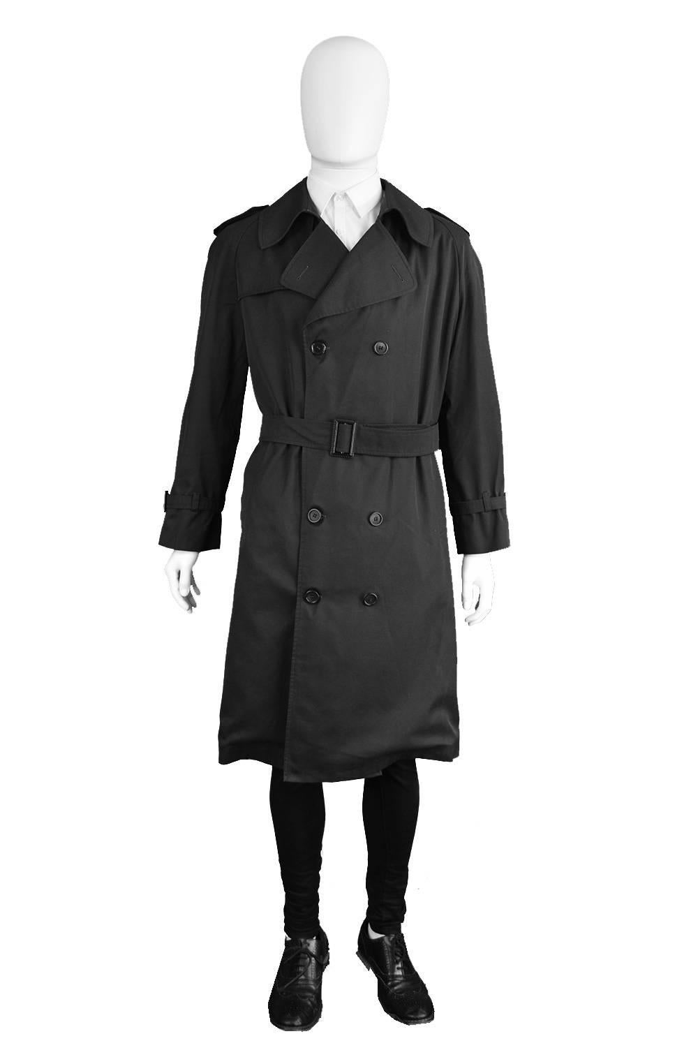 A sophisticated and sartorially excellent vintage Christian Dior Monsieur Paris trench coat with double breasted buttons and a belt which pulls in the waist and gives a more flattering, modern look.  In a dark, almost black, charcoal grey polycotton