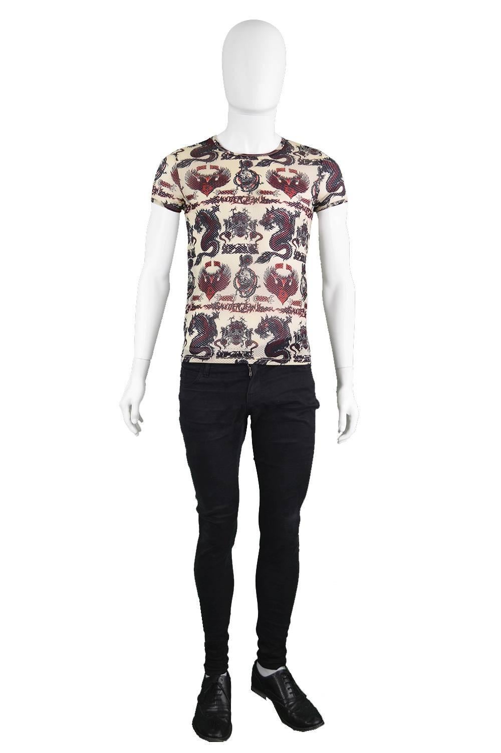 A cool vintage men's Jean Paul Gaultier shirt from the 1990s for the Gaultier Jean's line. In a nude coloured mesh fabric with tattoo imagery all over, including barbed wire 'Gaultier Jeans' symbols, dragons and hearts. Tight fitting which means it