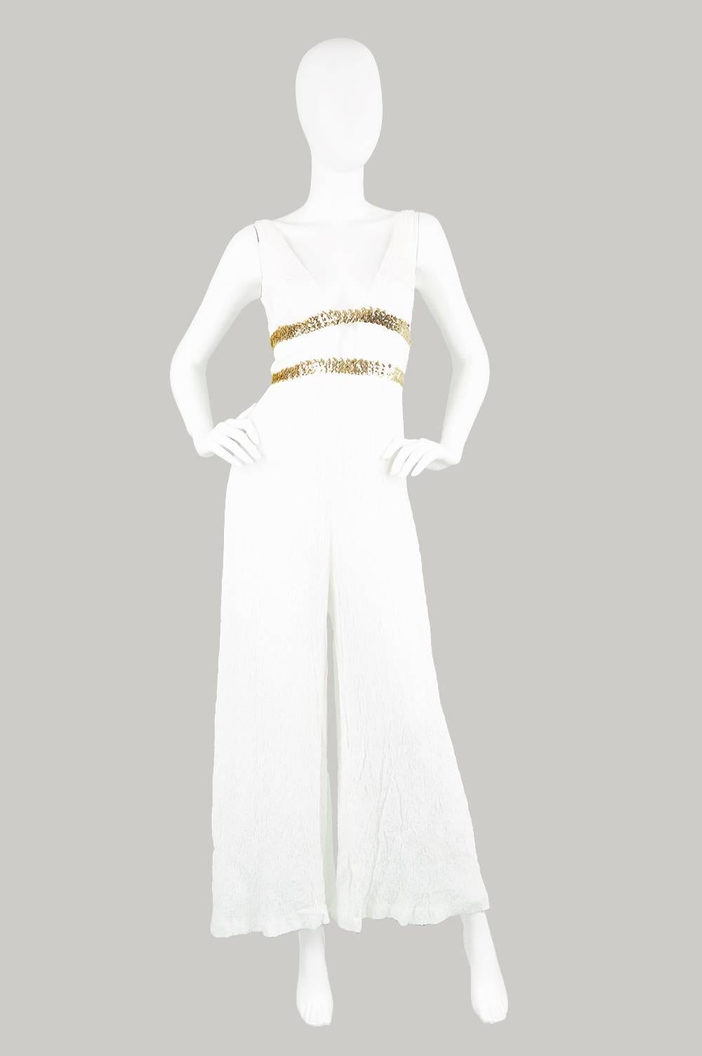 A stunning vintage jumpsuit from the 1970s, by highly collectible British label, Jean Varon, which was designed by John Bates who is renowned for his space age mod looks in the 60s and ethereal, Grecian bohemian gowns in the 70s. With it's wide,