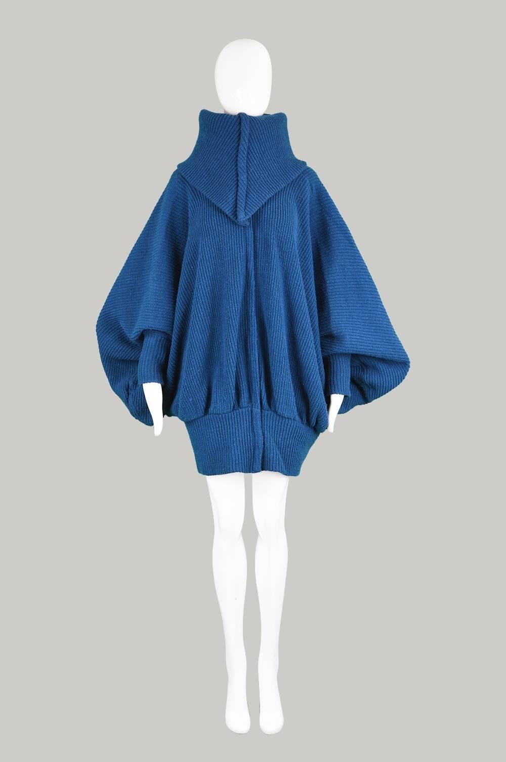 An incredible avant garde vintage batwing jacket from the 1980s by highly collectible and genius designer, Norma Kamali, for one of her earlier labels. In a ribbed chunky knit fabric with a dramatic, draped effect created by the extreme batwing -
