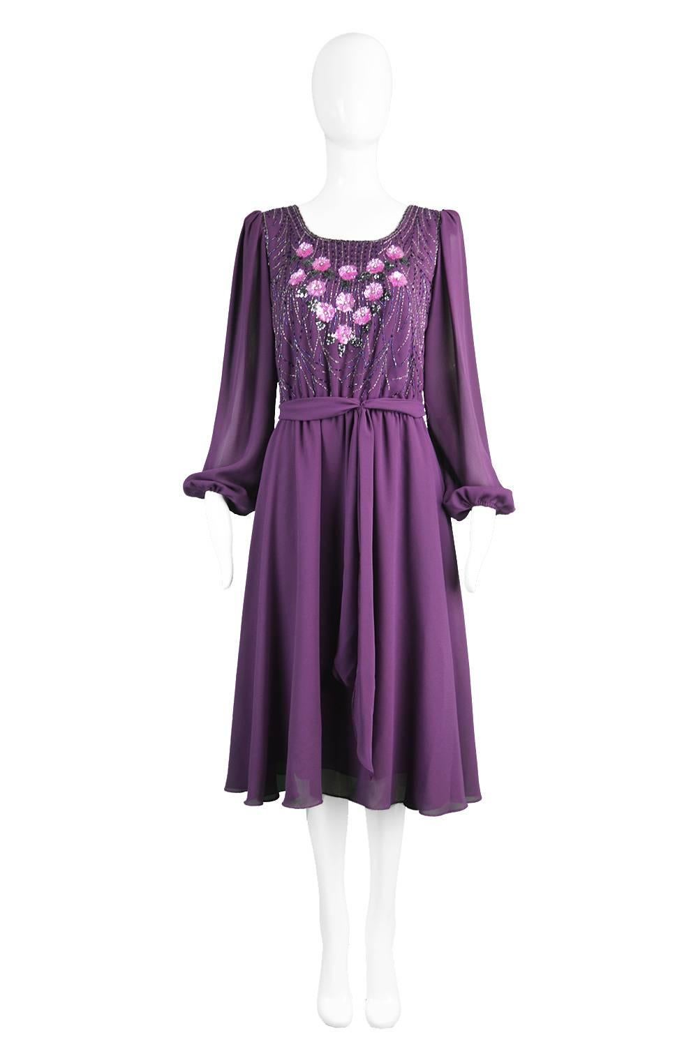 A glamorous purple vintage beaded dress from the 1970s with billowing chiffon balloon sleeves by Jack Bryan.

Estimated Size: UK 12-14/ US 8-10/ EU 40-42
Bust - 38” / 96cm
Waist - Stretches from 26-32” / 66-81cm
Hips - Free
Length (Shoulder to