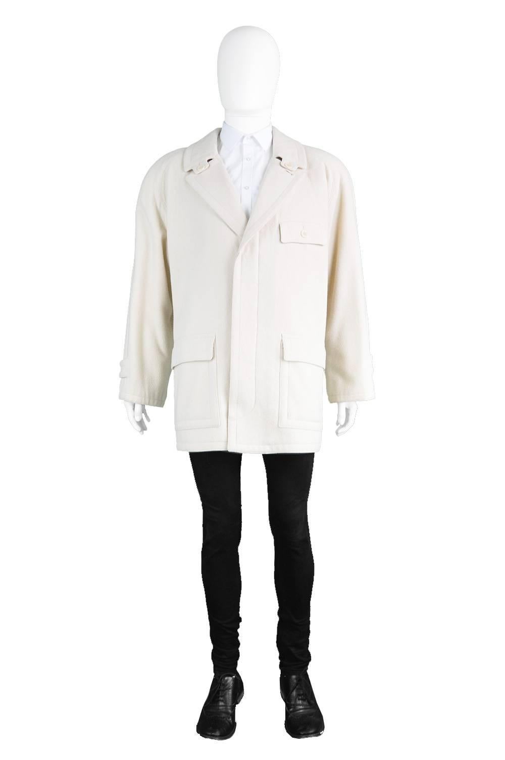 A timeless vintage wool coat from the 1980s by luxury French designer and couturier, Louis Féraud for his rare 'monsieur' mens line. Made in Italy, in a cream Italian wool, the raglan sleeve, patch pockets and concealed button placket all give the
