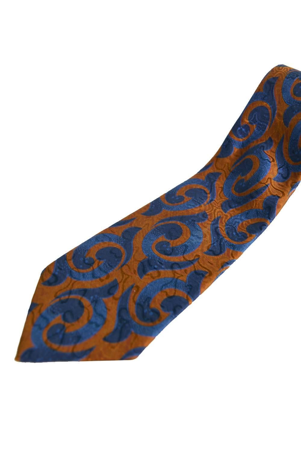 A classic vintage mens necktie from the 80s by French luxury fashion house, Pierre Balmain. In a dark orangey-brown and blue silk with a satin jacquard throughout.

Total length - 58