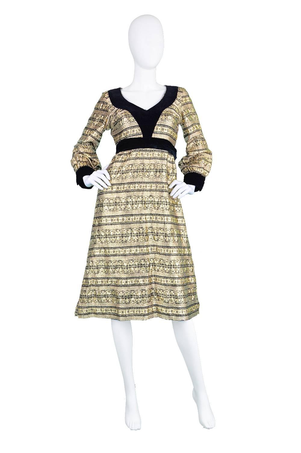 An incredibly elegant vintage dress from the 1970's by genius and increasingly collectible vintage designer, Jean Varon (Who was also known as John Bates). In a shimmering gold lamé fabric with a brocade pattern throughout, this dress really