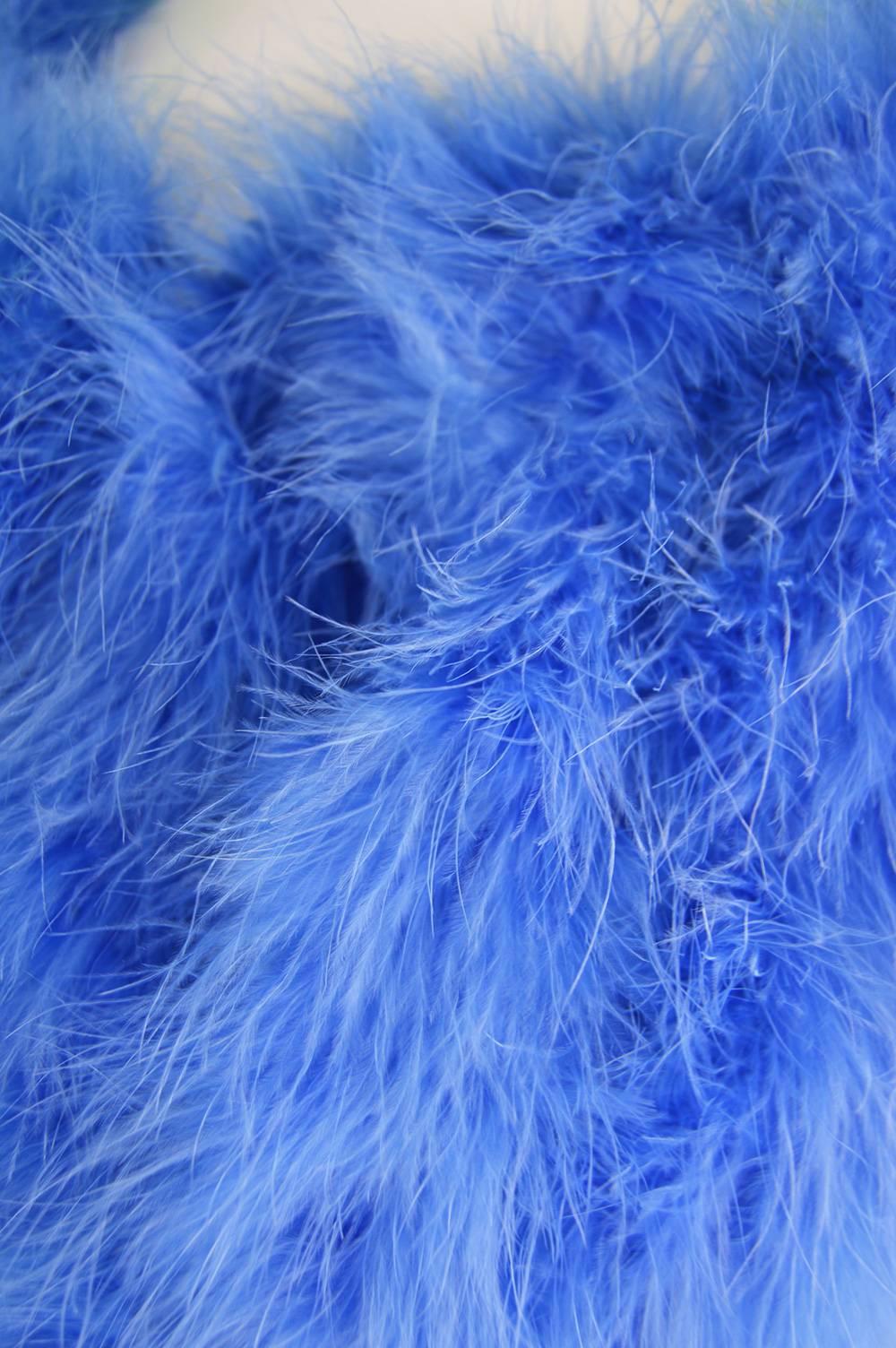 A glamorous vintage bolero jacket/ shrug from the 1960s by Sybil Zelker for Polly Peck. In a blue synthetic jersey with strips of fluffy marabou feathers to add a touch of glamour to any outfit. 

Estimated Size: Women's Small
Bust - up to 36