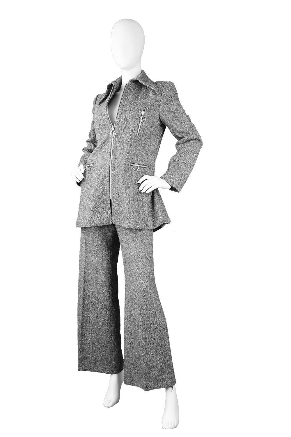 An incredible, rare vintage womens flared pant/ trouser suit from the 1970s by luxury French designer, Ted Lapidus. Considered a pioneer of unisex fashion and the safari suit, this is an excellent example of Lapidus' work. In a grey wool tweed with