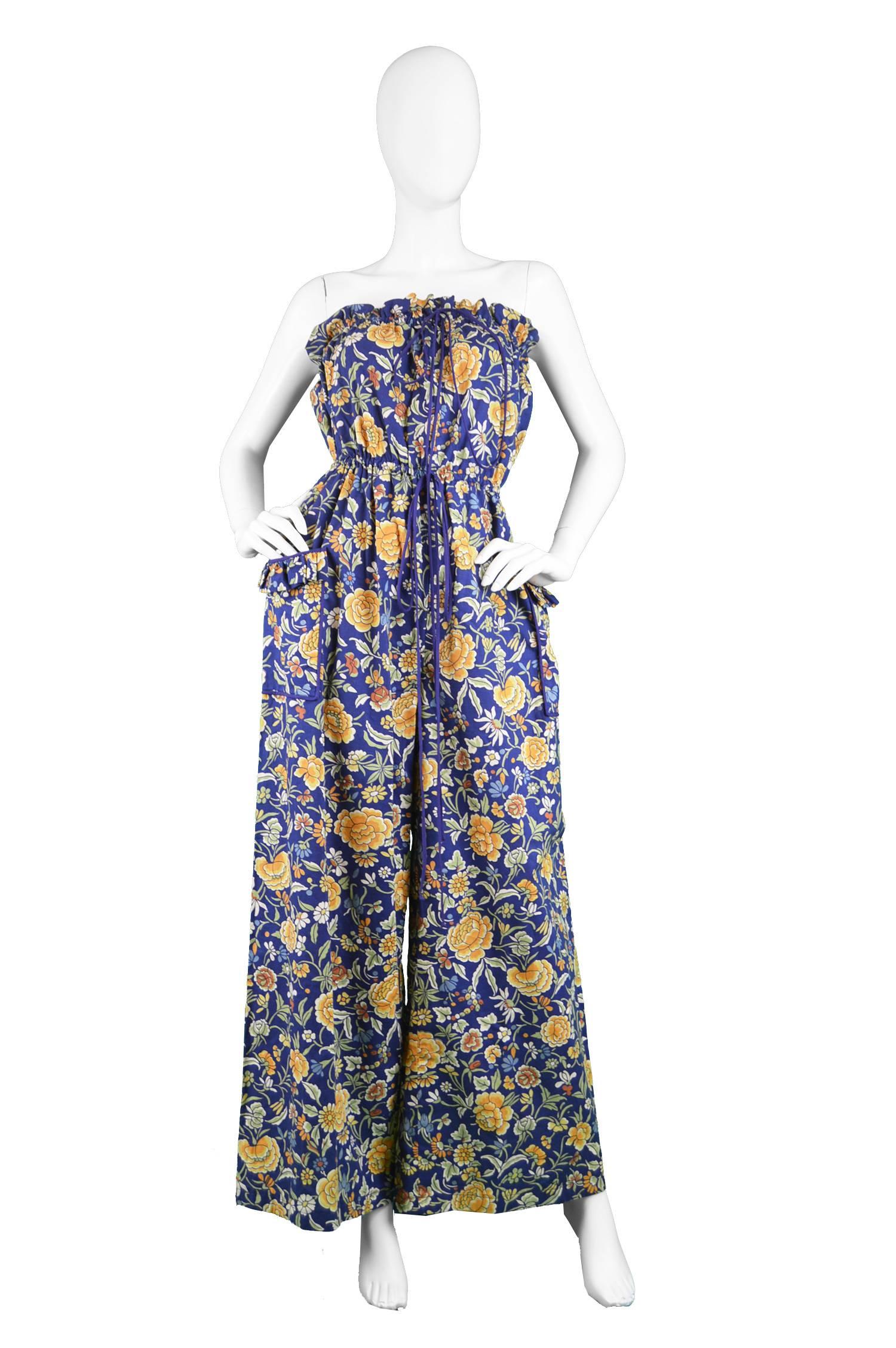 A stunning vintage women's jumpsuit from the 70s by British boutique label 'Salvador' in one of Liberty's legendary and highly collectible printed cottons. With a wide leg, elasticated waist and strapless body - which gives such a flattering,