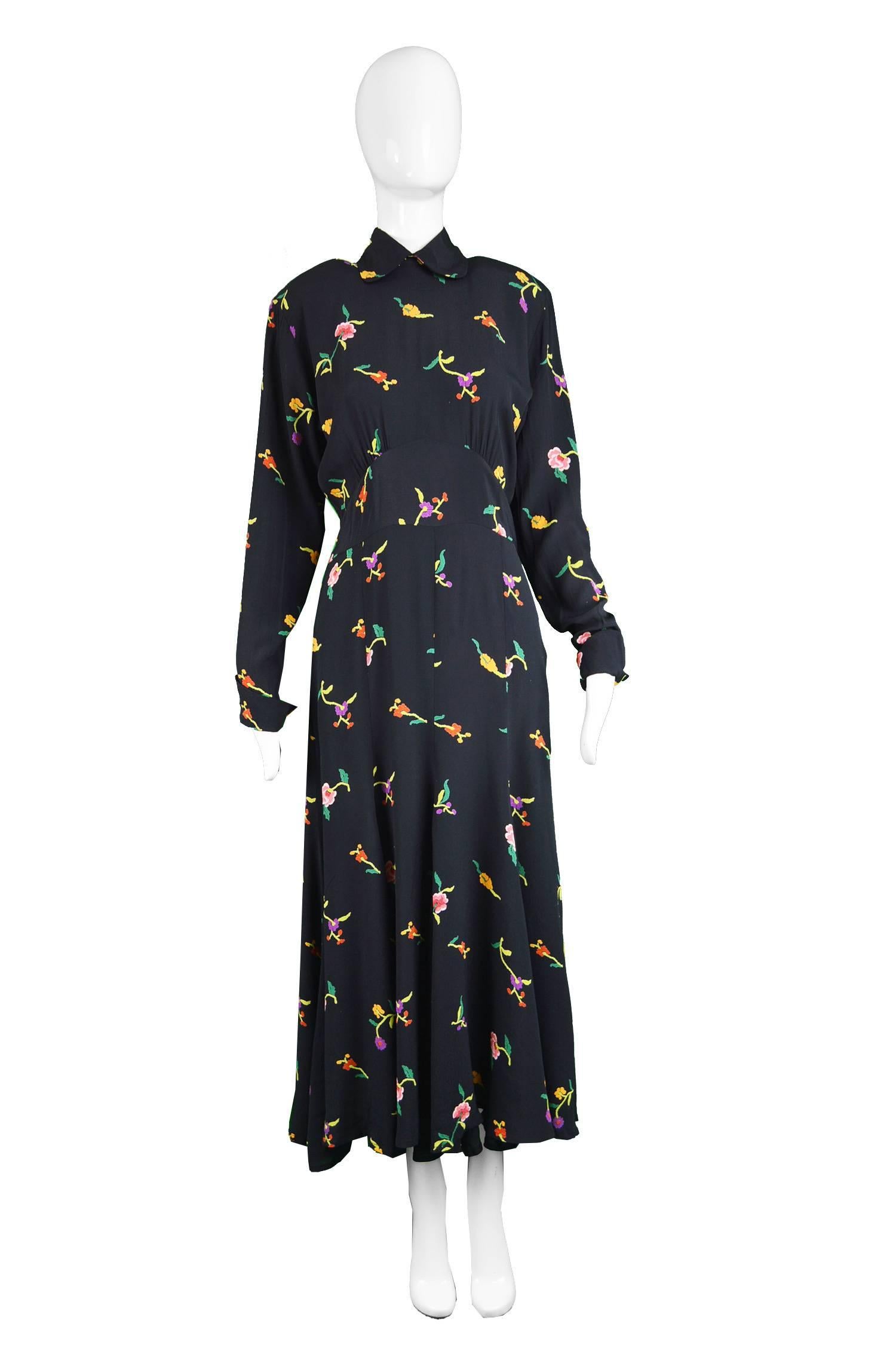 A stunning vintage Norma Kamali dress from the 80s in a black rayon crepe which has incredible drape, with a feminine, chinoiserie inspired floral print that looks almost like embroidery from a distance. The bold shoulder pads mixed with the drape