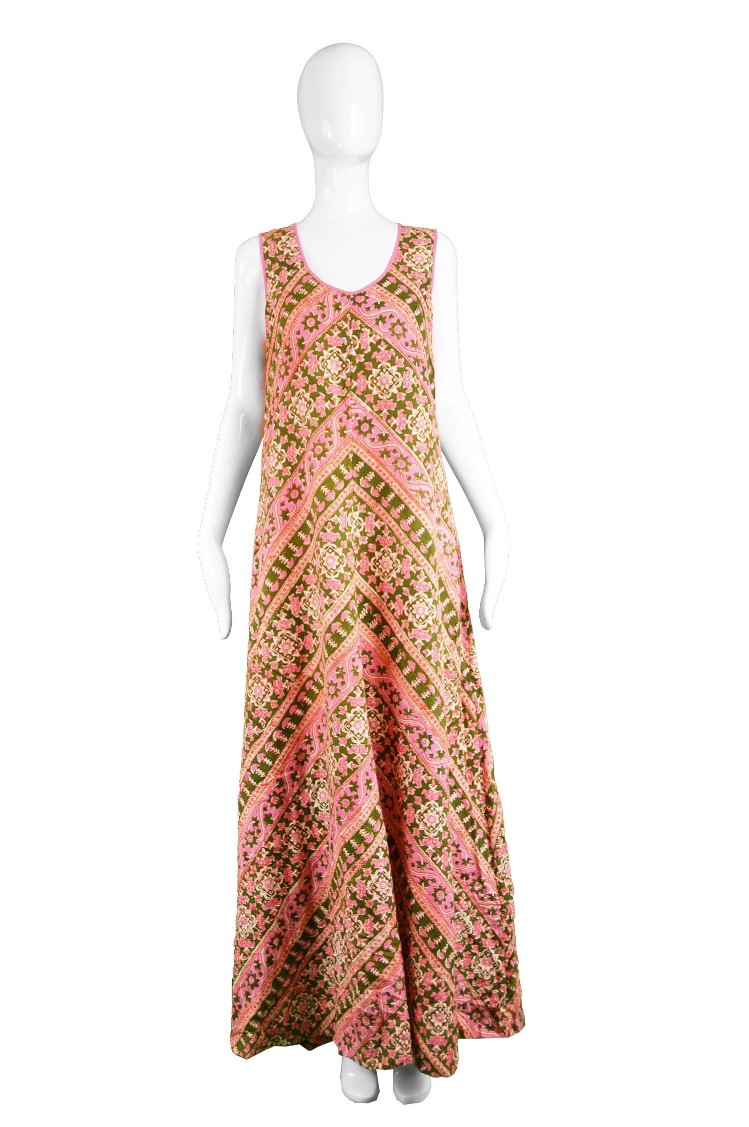A beautiful vintage maxi dress from the 70s by legendary Indian cotton designer, Anokhi. In a soft pink and green block printed Indian cotton lawn which gives a bohemian luxe look which is furthered by the long, sleeveless column silhouette which