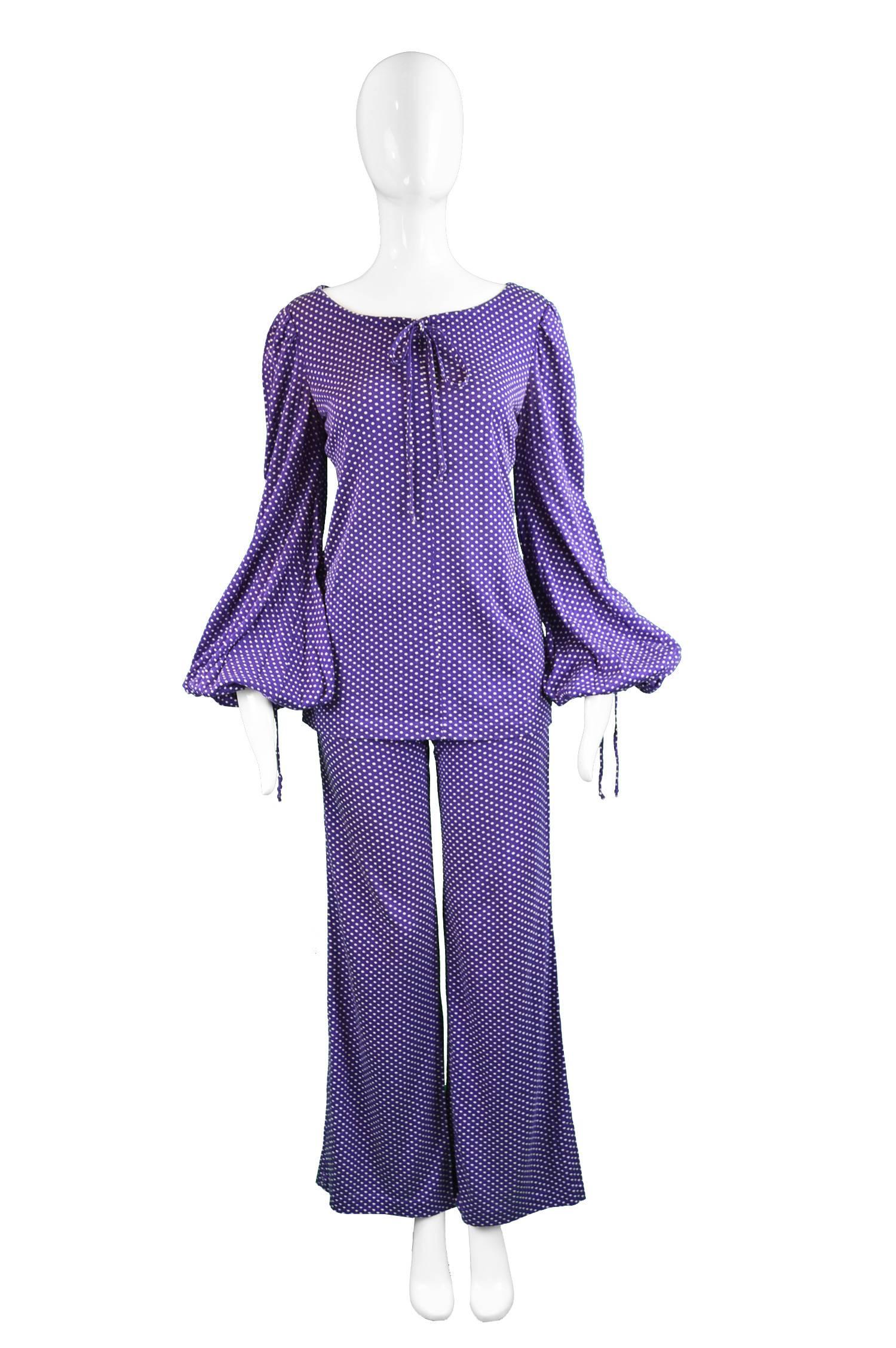 An incredibly rare and highly collectable original vintage two piece pant suit from the early 70s by legendary British label, Biba. In a stretchy purple knit fabric with playful white spotty polka dot print throughout. The tunic top, which could be