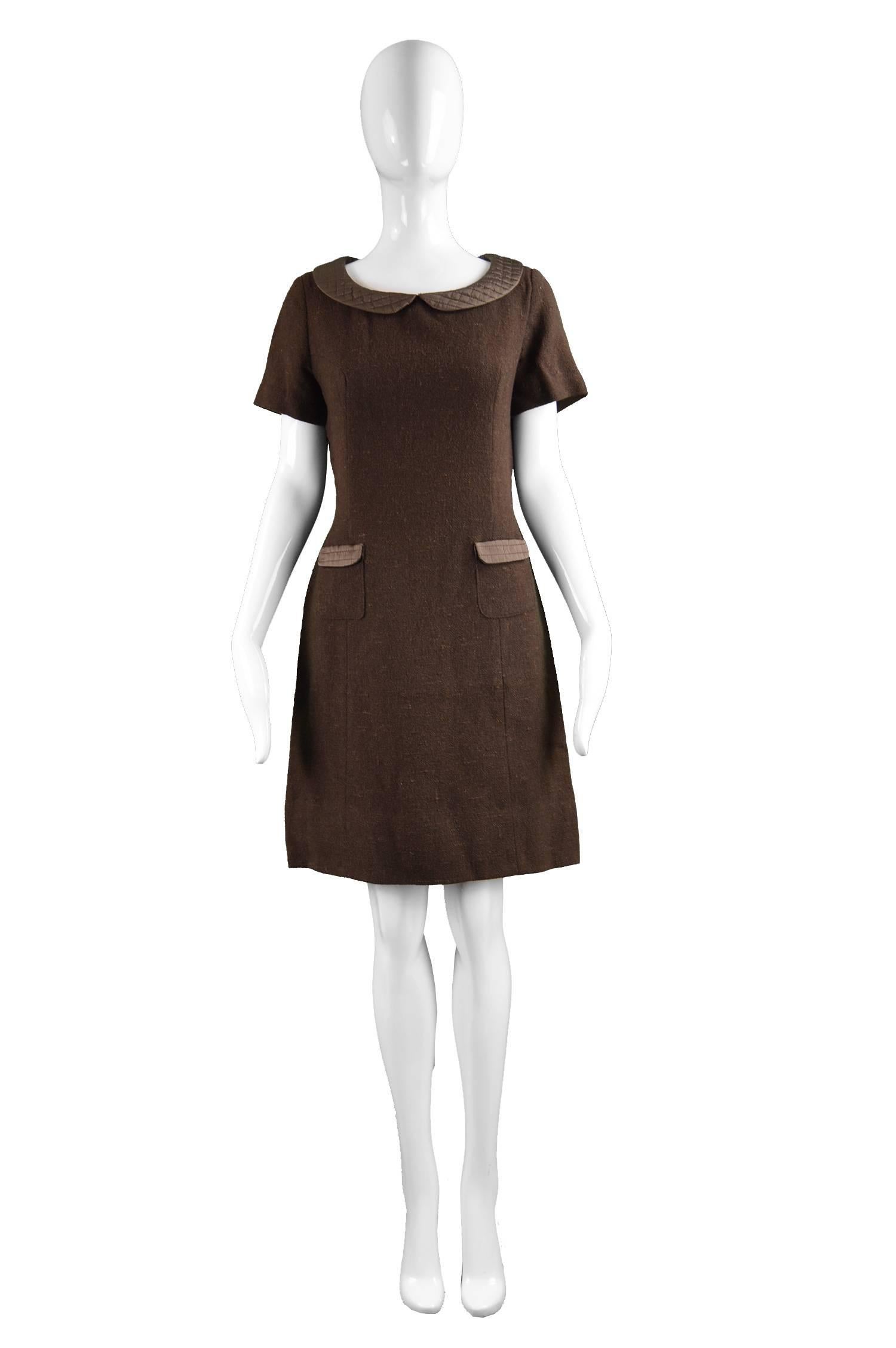 A chic vintage women's dress from the 60s by high quality ready to wear label, Marcel Fenez. In a brown woven wool with matelassé quilting on the pockets and peter pan style collar which gives a playful mod touch. With simple and elegant tailored