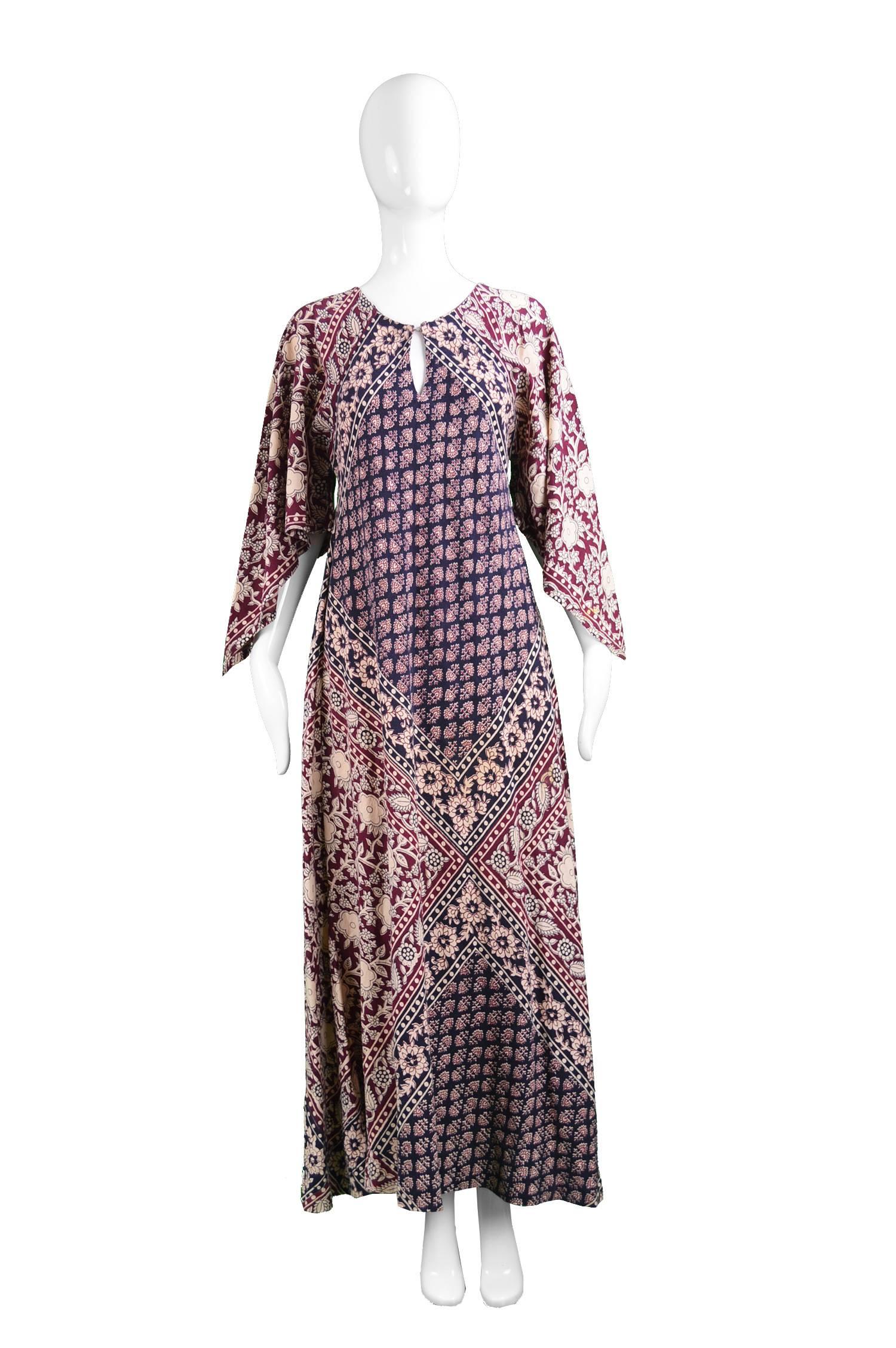 A beautiful vintage bohemian maxi caftan dress with a loose flowing fit from the 70s with a striking Indian floral block print throughout a medium weight cotton with pointed sleeves that gives a striking ethnic hippie look, perfect for summer days.
