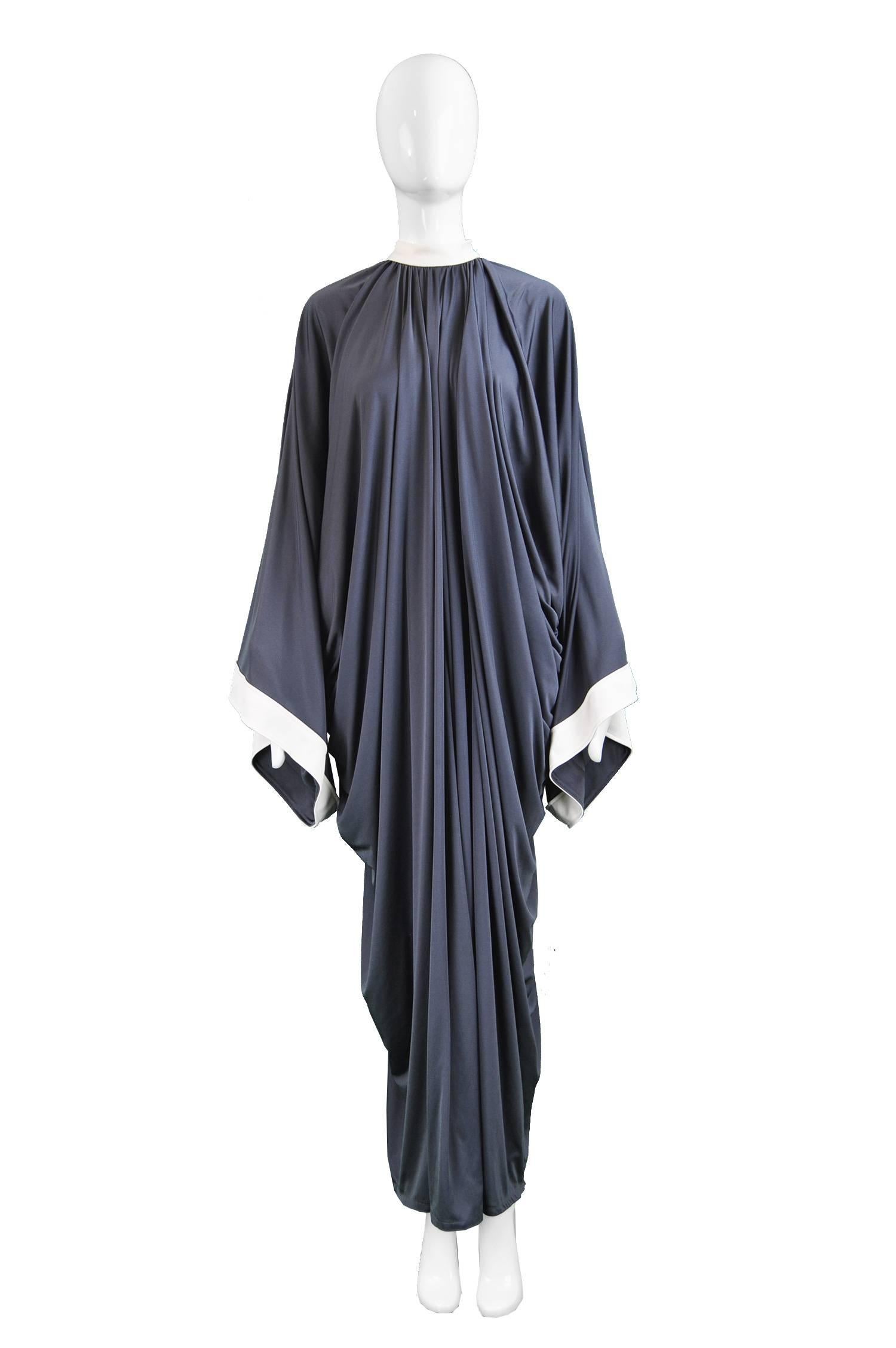 Yuki Draped Jersey Monastic Grey & White Kimono Sleeve Evening Gown, 1970s

Size: One Size Fits All - meant to have a loose, kaftan style fit, as pictured. 
Bust, Waist & Hips - Free
Length (Shoulder to Hem) - 58” / 147cm
 
Condition: Excellent