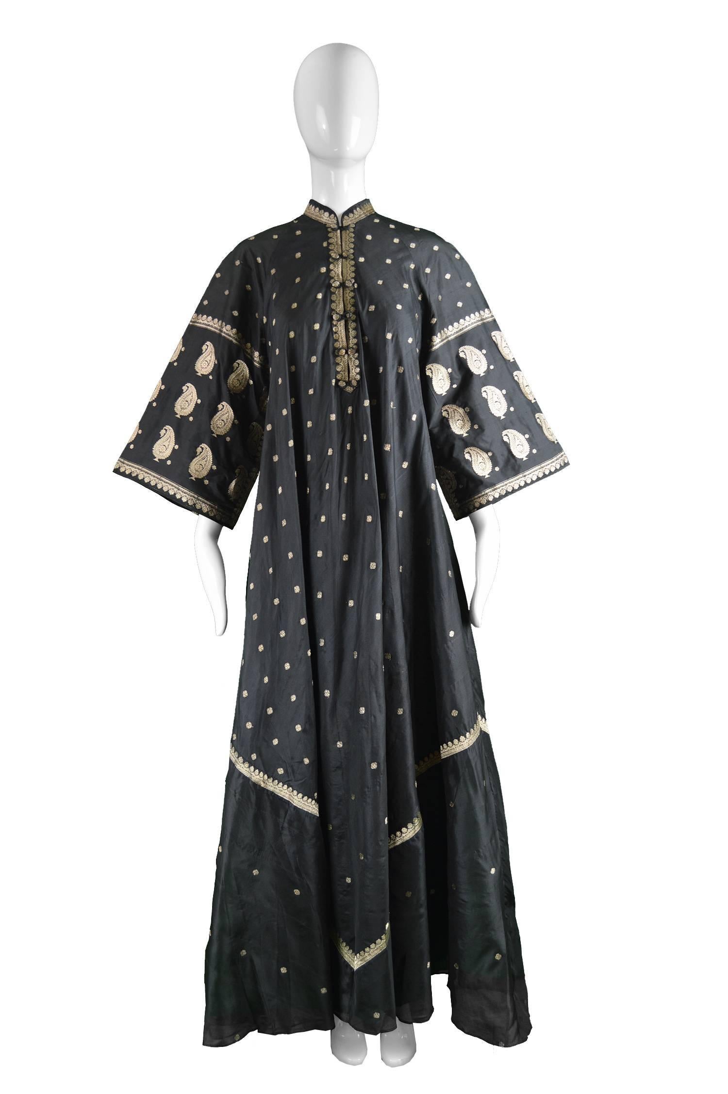 Indian Silk Black & Gold Lamé Brocade Vintage Maxi Kaftan Dress, 1970s

Estimated Size: Would suit a Small to Large due to loose, flowing silhouette. 
Bust - up to 42” / 106cm
Waist - Free
Hips - Free
Length (Shoulder to Hem) - 57” /
