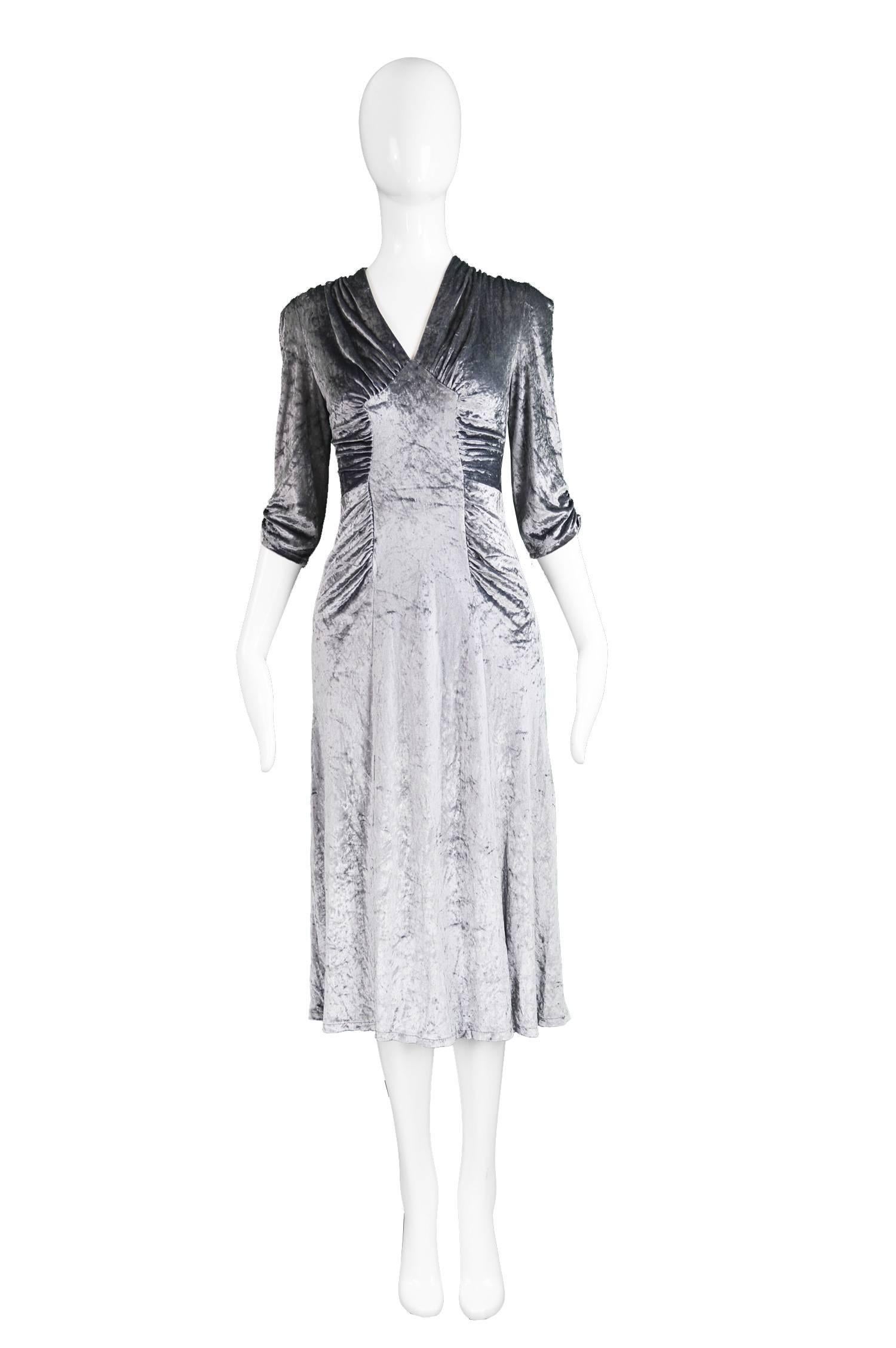 Irvine Sellars of Carnaby Street Vintage Silver Velvet Dress, 1970s

Esimated Size: UK 10/ US 6 / EU 38. Please check measurements. 
Bust - 34” / 86cm
Waist - 30” / 76cm
Hips - 36” / 91cm
Length (Shoulder to Hem) - 45” / 114cm
Sleeve Pit to Cuff -