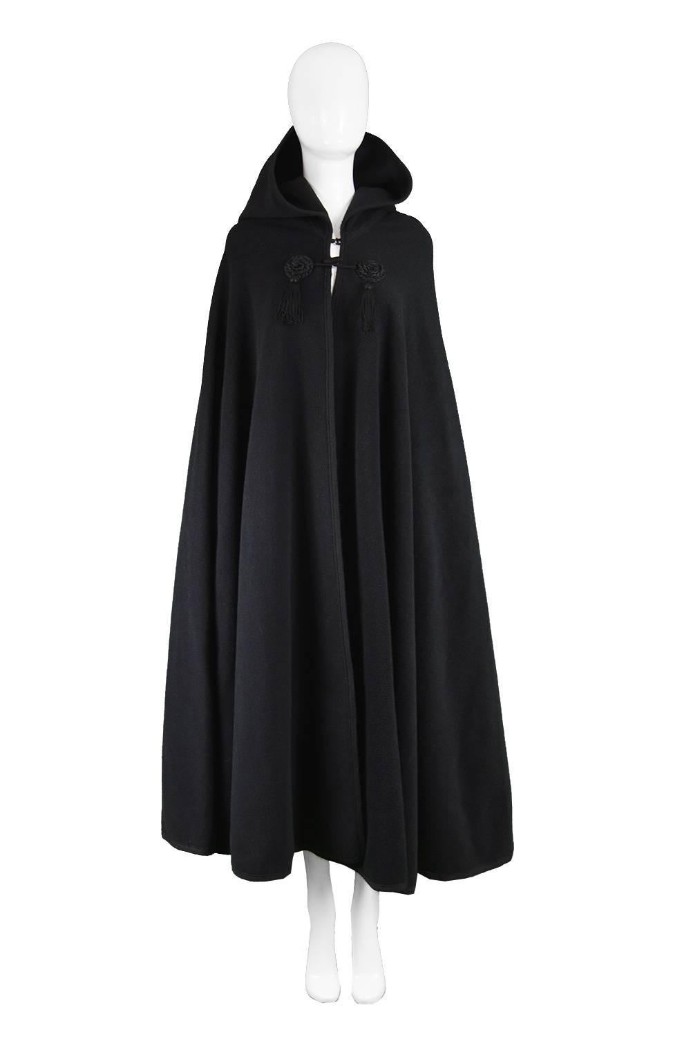 Harrods Younger Set Vintage Tasselled Black Wool Hooded Cape Cloak, 1960s

Size: Best fits a women's Medium to XL due to huge fullness and long length.
Bust - Free
Waist - Free 
Hips - Free
Length (Shoulder to Hem) - 50” / 127cm
Shoulder to Shoulder