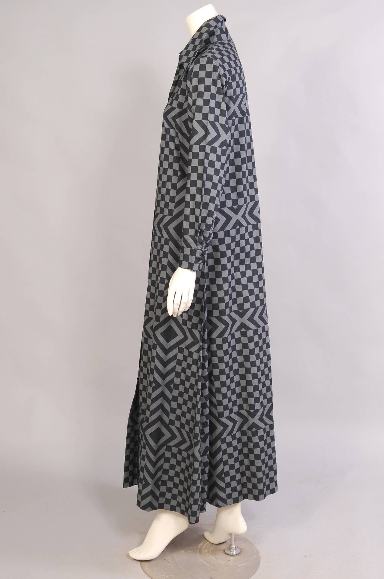 A chic black and grey color combination in the Ruuturita pattern, first designed in 1974, makes a very chic long cotton dress for day or evening. The dress buttons down the front, comes with a matching belt, and it is marked a size 42/14. It is in