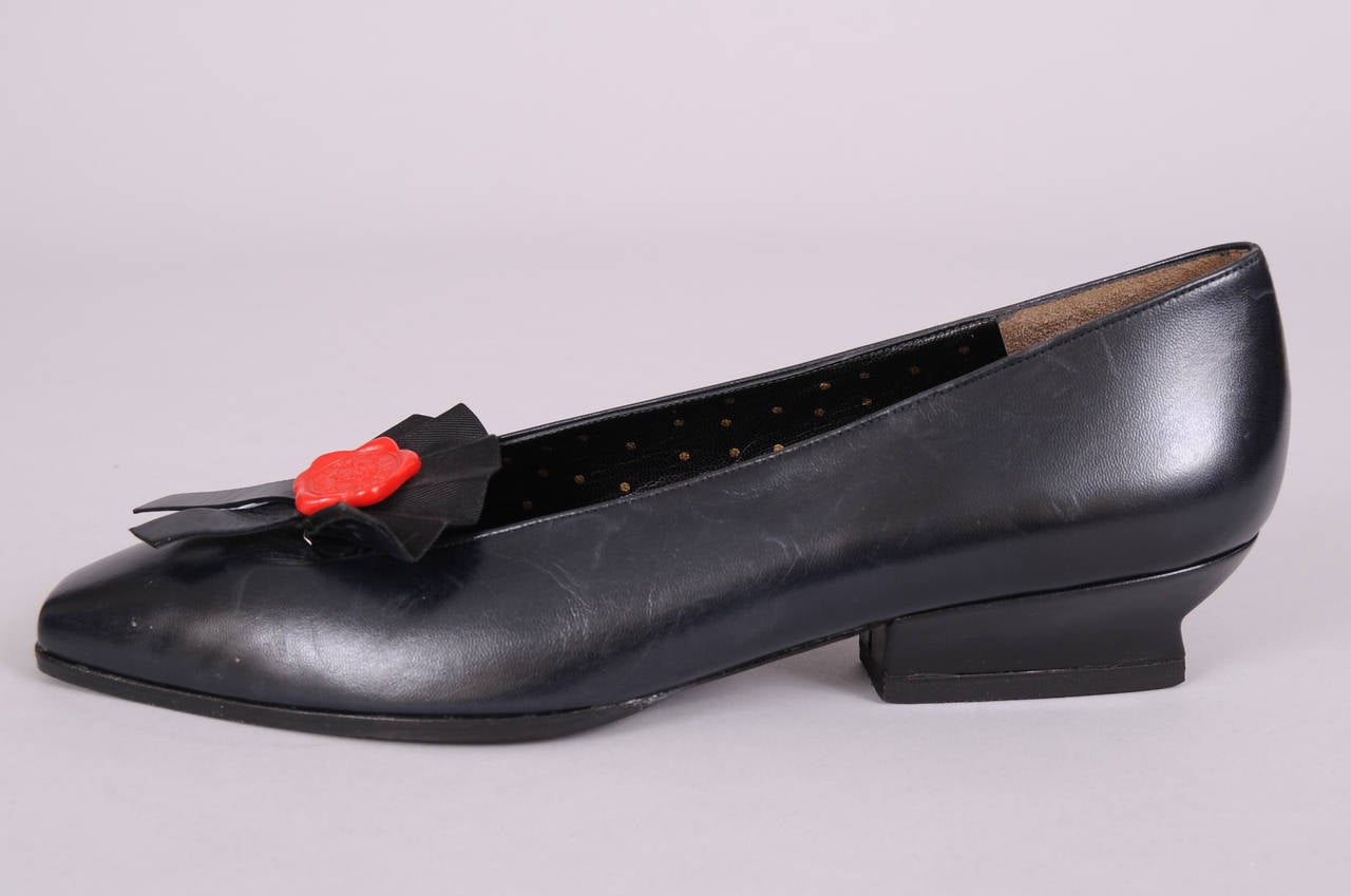 These black leather flats have a distinctive Karl Lagerfeld treatment. They are adorned with his ever present black fan and a red wax seal. They are lined with gold dotted black leather and they have never been worn. Please let me know if you need