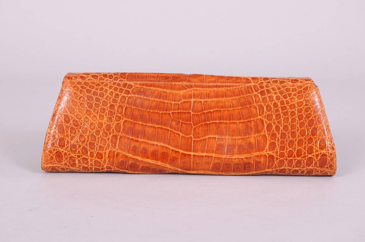 A sleek modern design brings this crocodile clutch into the 21st century. Honey brown crocodile skin is lined in leather. There is a slip pocket inside and it is in excellent condition.
Measurements;
Length 11