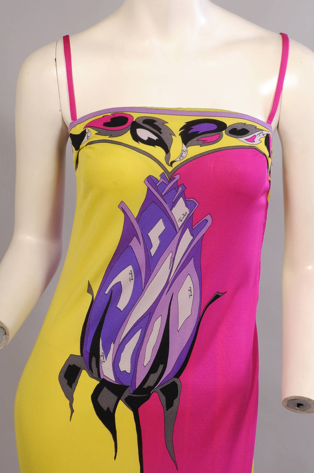A striking purple long stemmed rose bisects the front and back of this acid yellow and magenta silk jersey dress from the 1970's. A leaf pattern is used on the top and bottom borders. It is marked a vintage size 10, please check the measurements. It