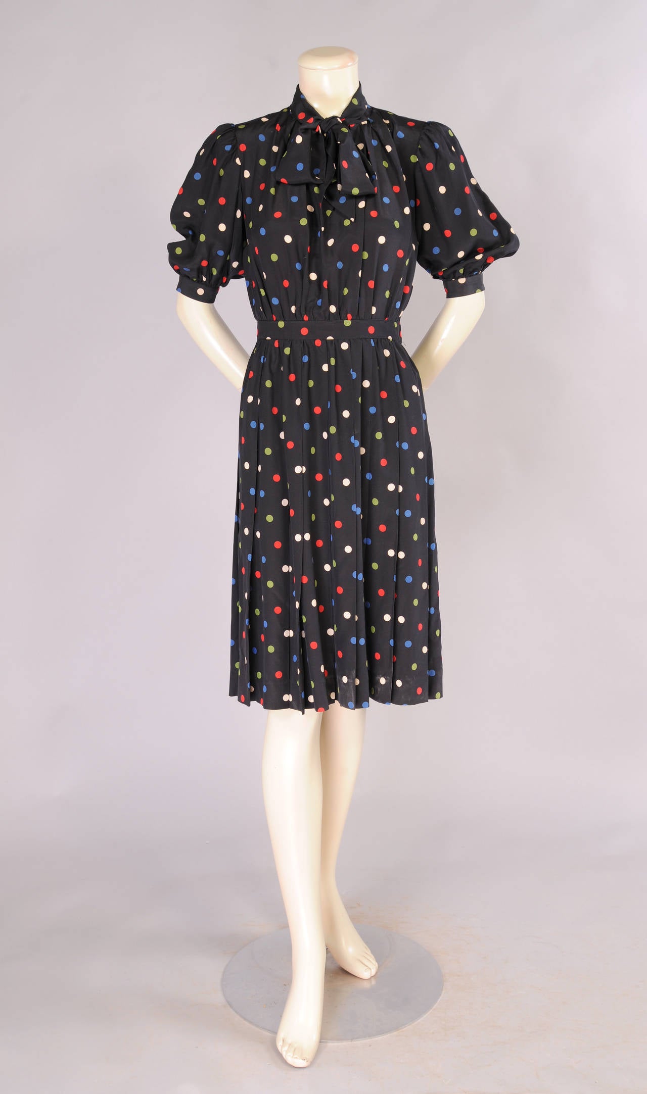 This 1940's inspired black silk dress has a pussy cat bow at the neckline, a fitted waist, stitched down pleats and a left side zipper. It is in excellent condition and marked a vintage size 36.
Measurements;
Shoulders 14