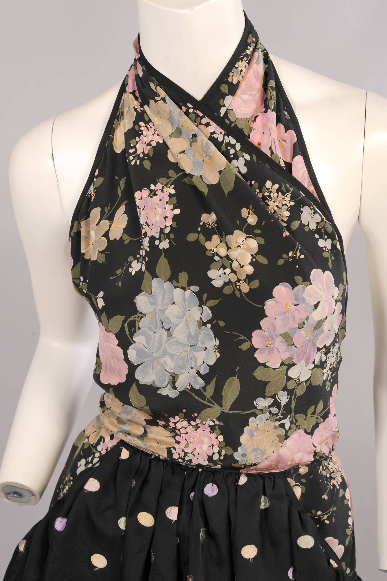 Pastel flowers on a black background are combined with pastel embroidered polka dots on a sheer silk skirt. This is edged with scalloped polka dot tulle to create a very feminine dress from Geoffrey Beene. The floral print extends below the waist 