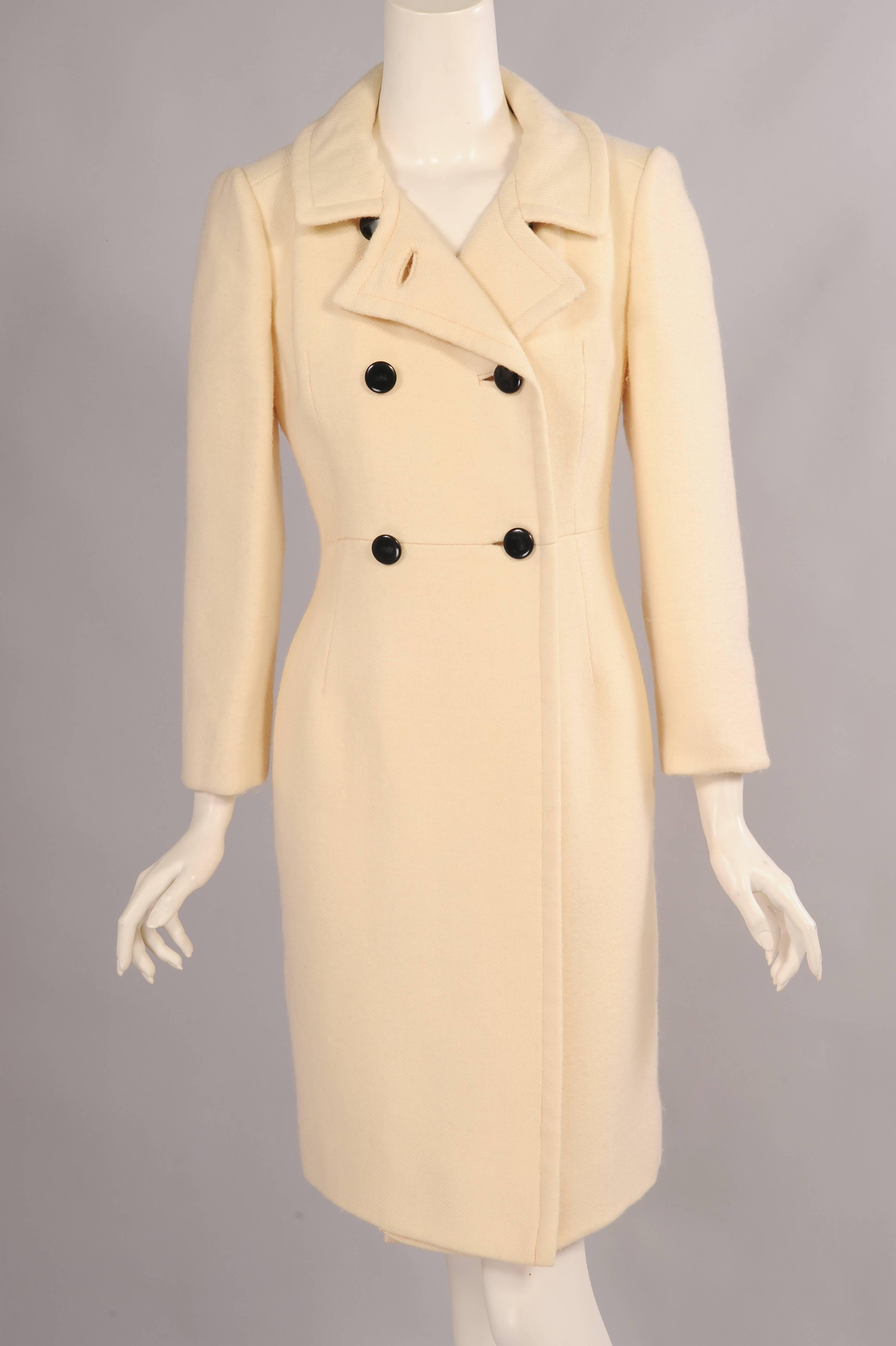 Cream colored wool, accented with six black buttons is used for this crisp, clean lined coat from the 1960's. Retailed by Bonwit Teller it is fully lined and in excellent condition.
Measurements;
Shoulders 16"
Bust 39"
Waist
