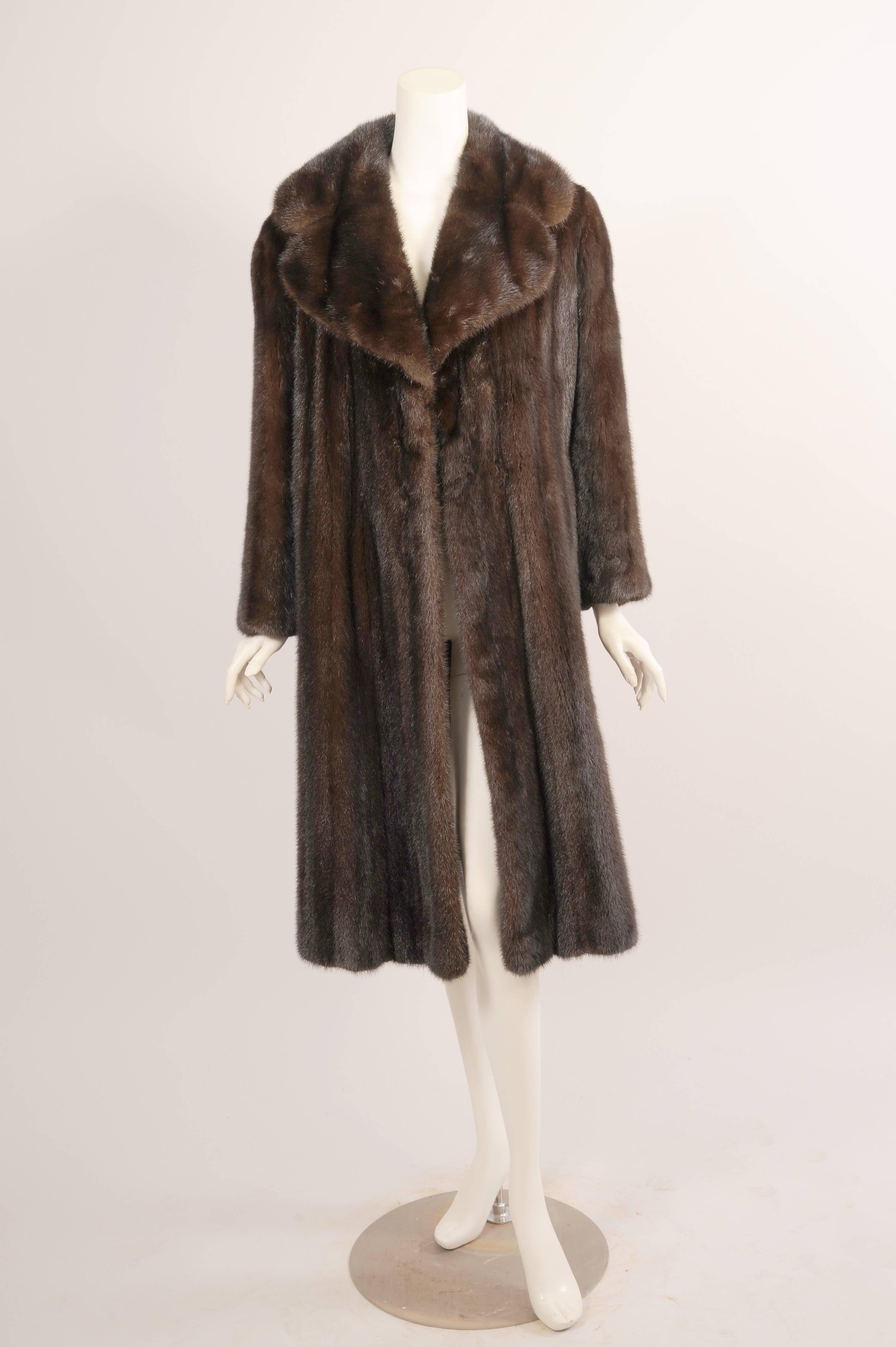 This gorgeous coat has a notched collar, concealed fur hooks, deep velvet lined pockets and a matching dark brown silk lining. The coat is in excellent condition. All measurements are taken on the outside of the coat while it is lying