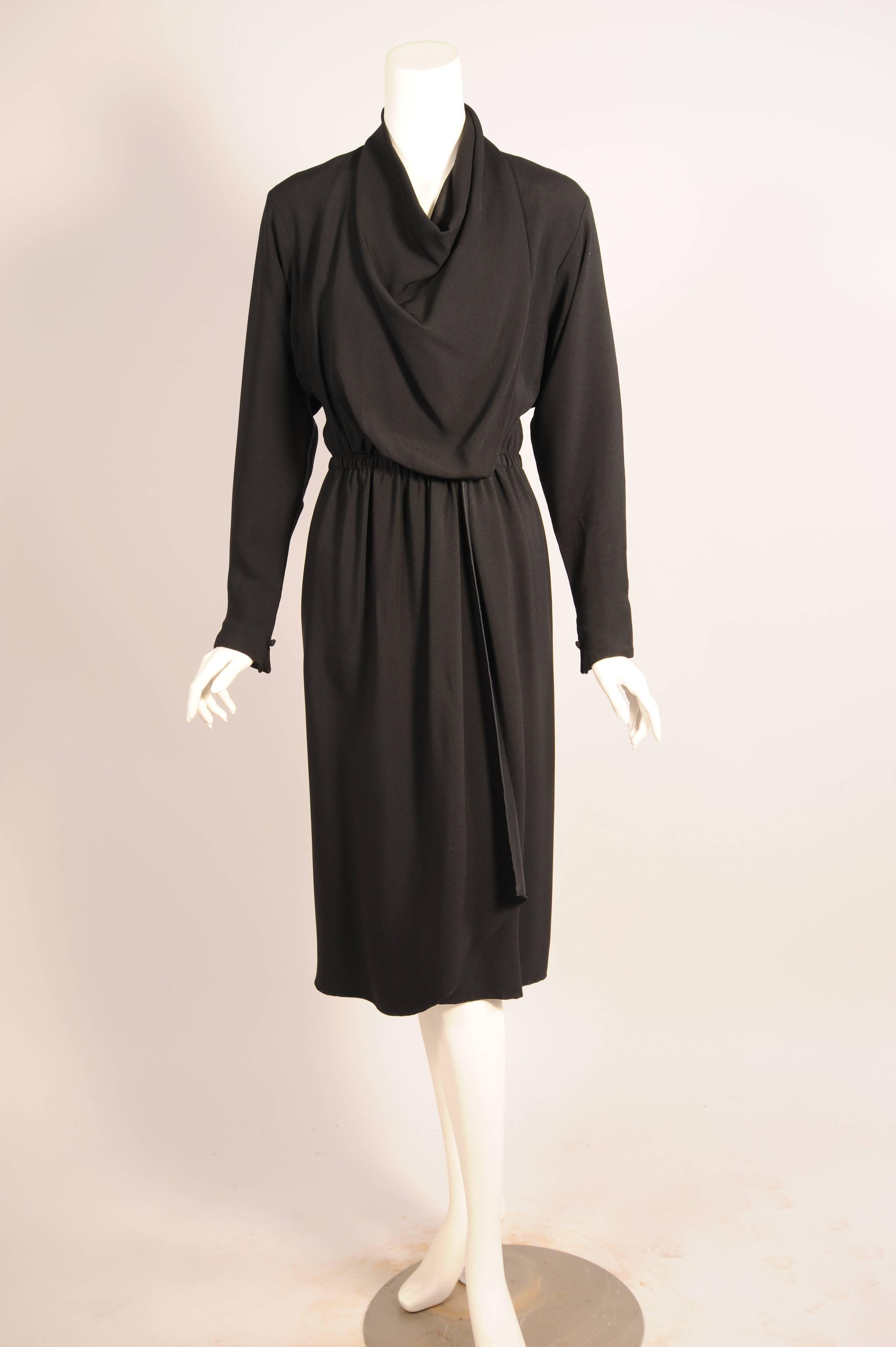 This sleek wrap dress closes to the left of center front while the draped bodice wraps around the neckline and closes to the right of center with a button and loop closure creating a beautiful drape. The long sleeves have a matching button and loop