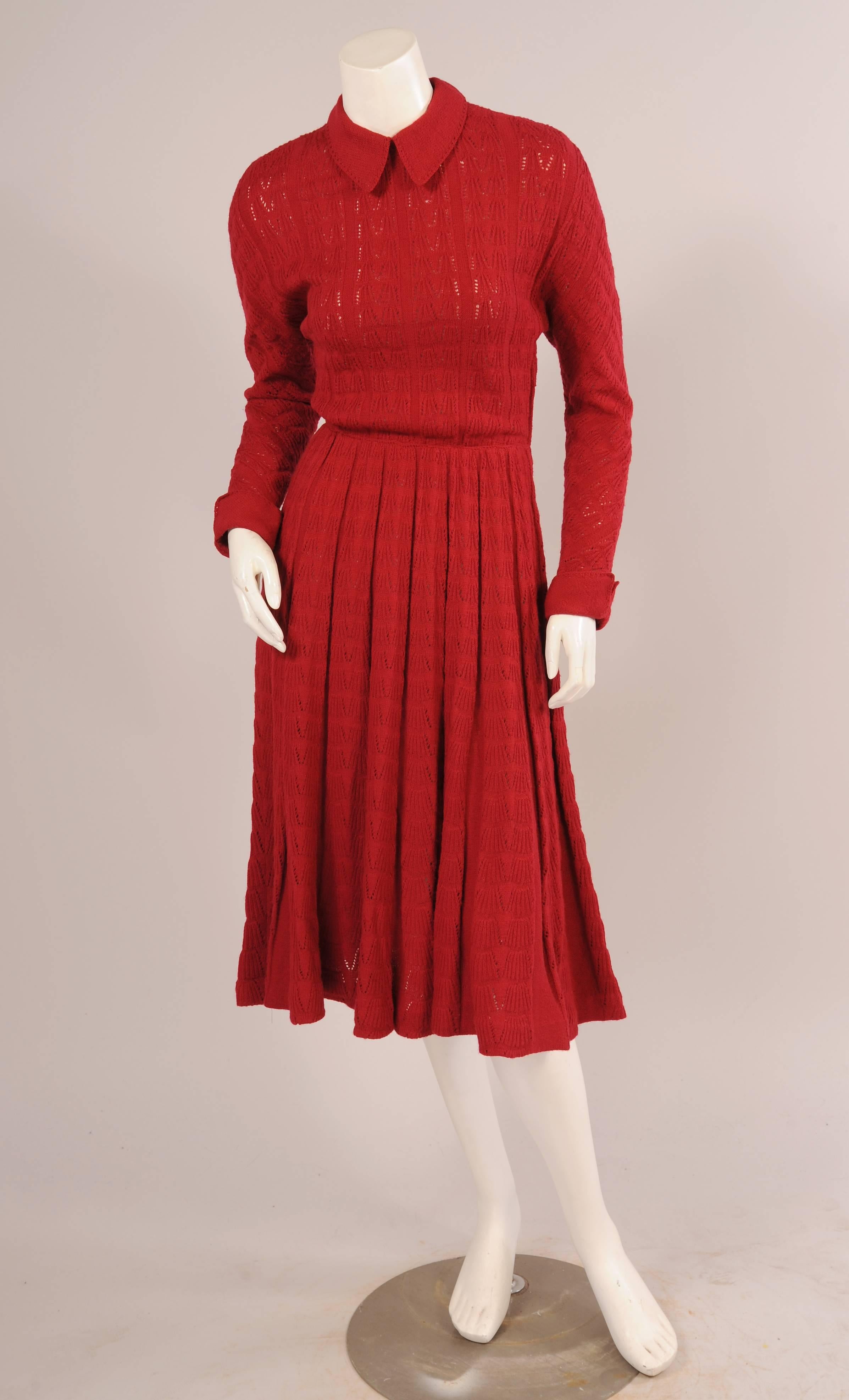 This dress has a sweet knit collar and cuffs and a great vertical knit design The long sleeves appear to be knit on the diagonal and the full skirt is narrow over the hips. There is a short zipper at the center back as well as a left side zipper.