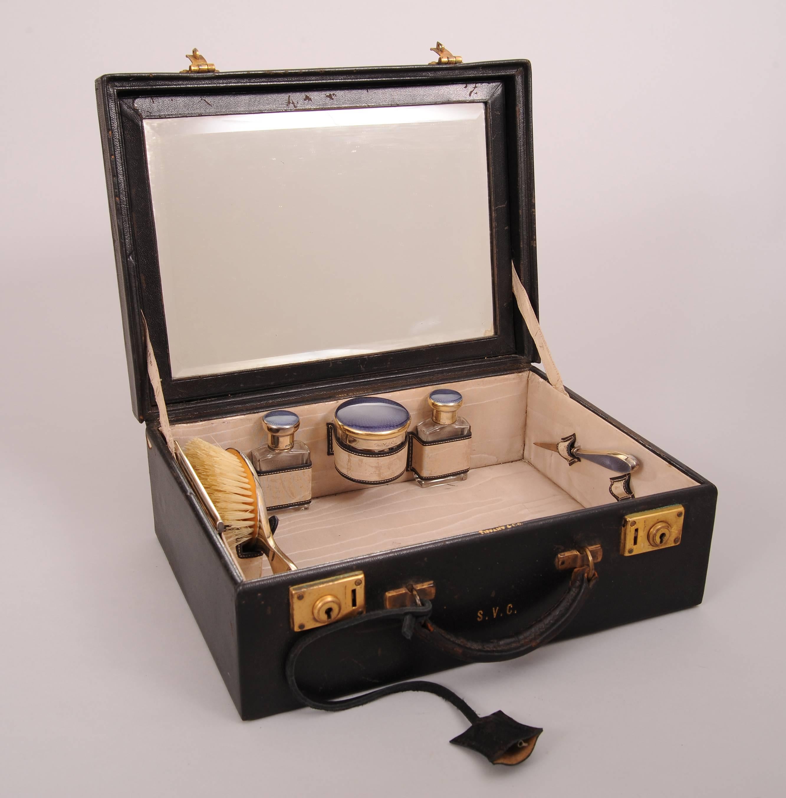 This charming Tiffany & Co. travel vanity is fitted with dusky purple enamel topped pieces. They are all sterling silver with a gold vermeil finish. The pieces bear the 1927 English hallmarks of Adie Brothers, Ltd. Birmingham. The case is marked