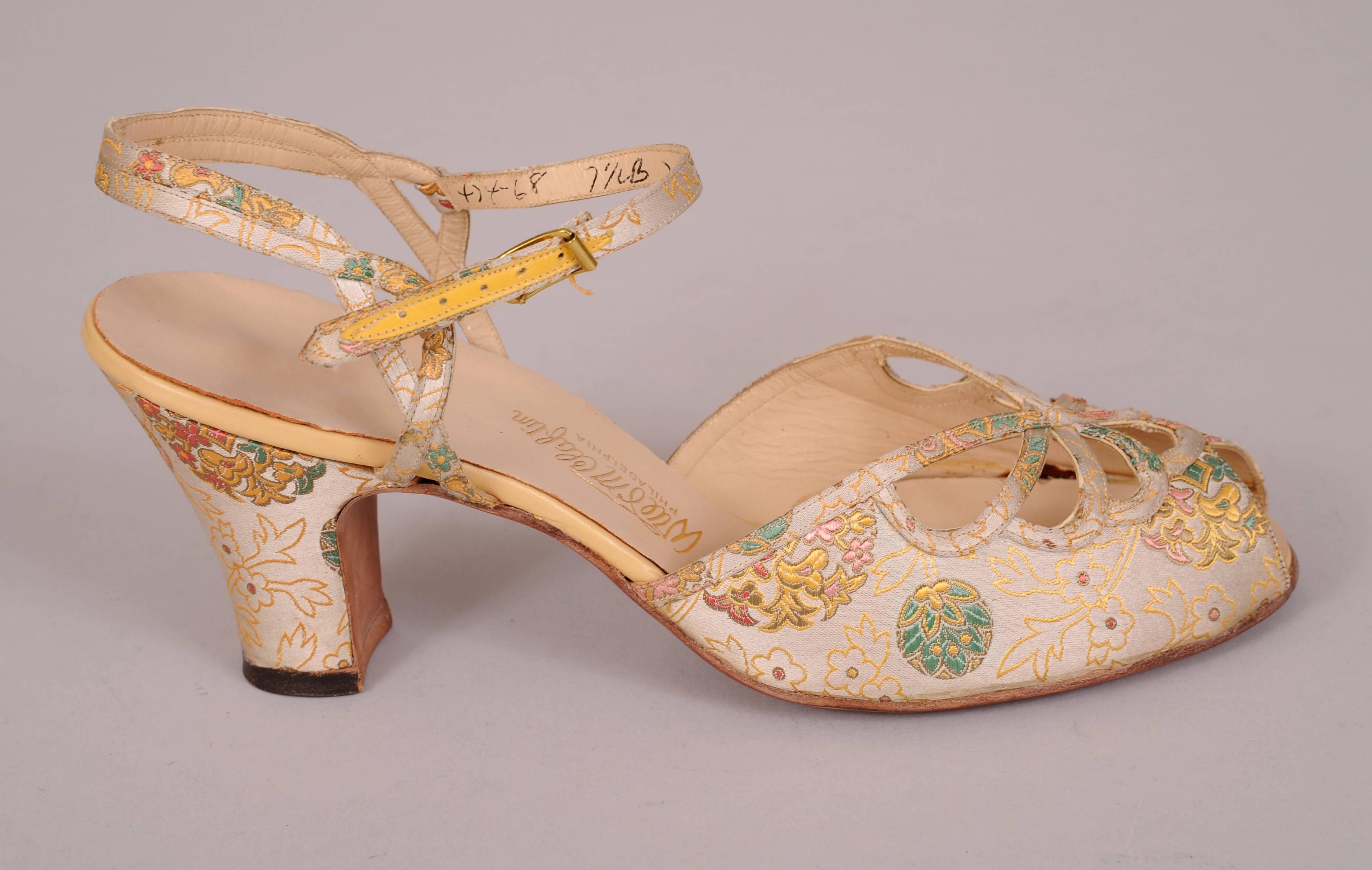 An Asian inspired brocade with a cream background and metallic gold, green, pink and red designs is used for these peep toe heels with a lattice work design which is repeated on the ankle strap. Never worn, they are in excellent condition, marked a