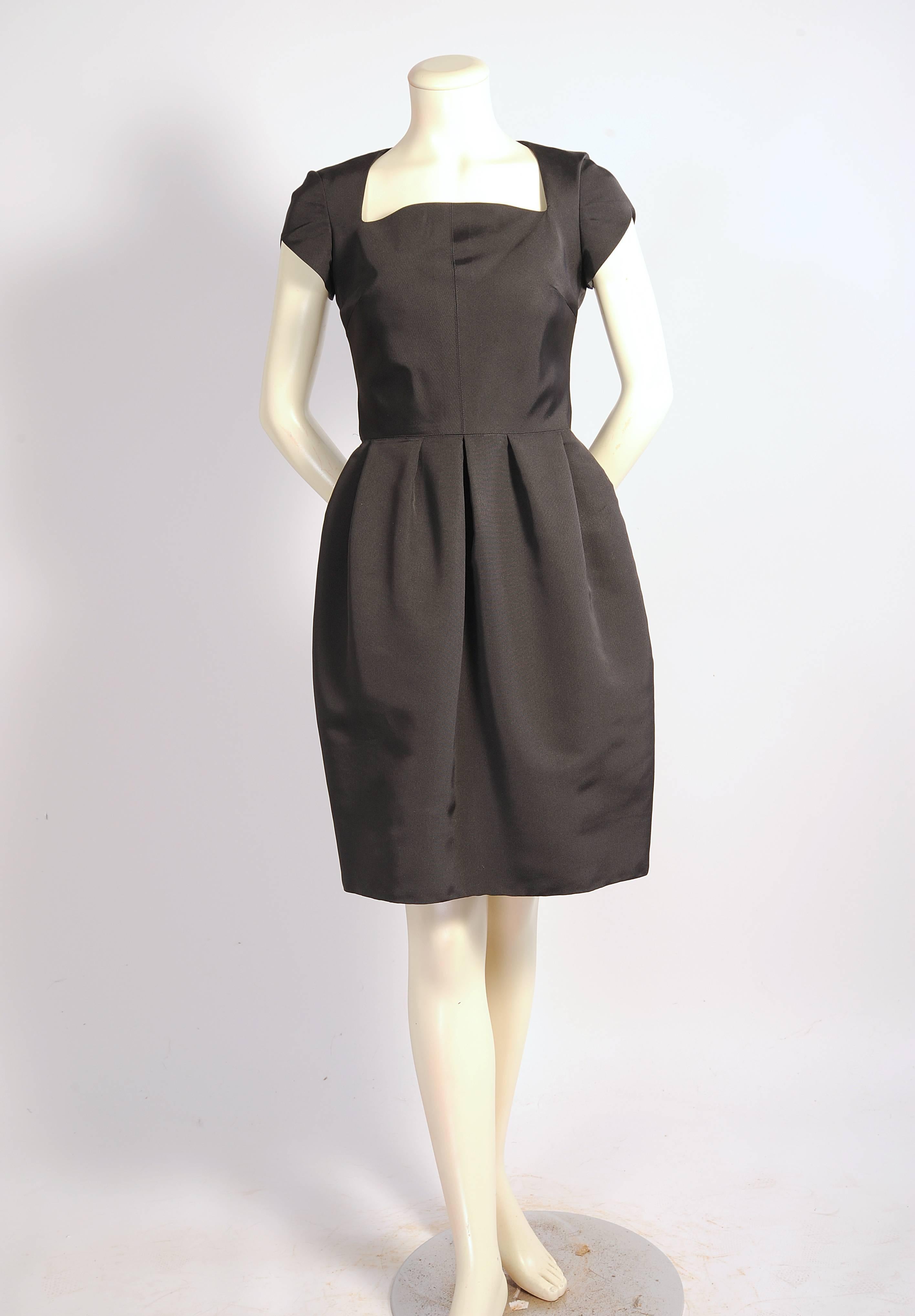 Th perfect jewelry dress, this chic black silk cocktail dress designed by Oscar de la Renta is a perfect dress for your best jewels. The dress has a square neckline and short sleeves above a fitted bodice, The gently gathered skirt is so flattering,
