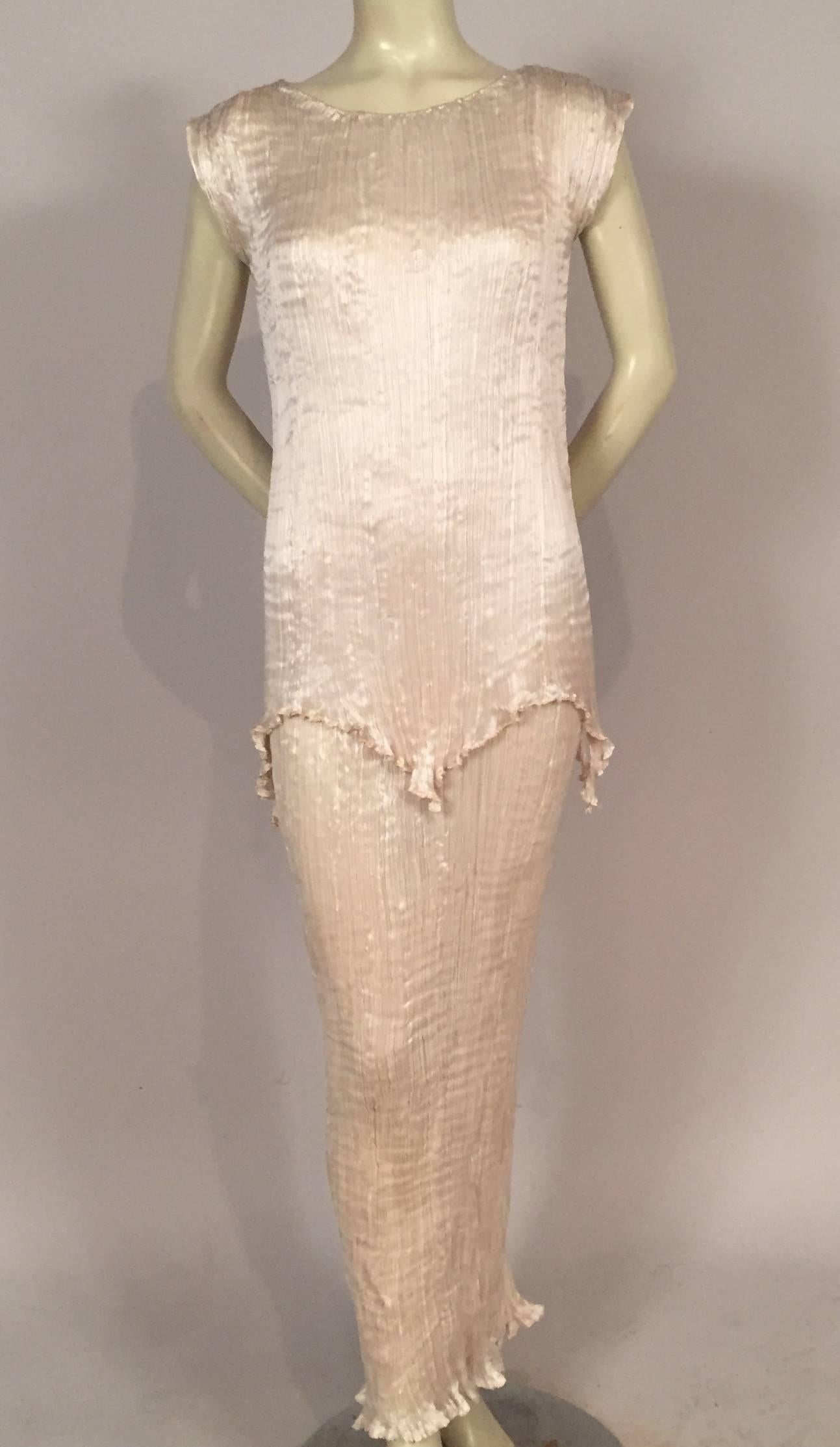 
This pleated ivory silk Fortuny Peplos dress is such a rare find, having never been worn, and still bearing the original price tag. It has remained at the same address since it was ordered from Elsie McNeil, the United States sole representative