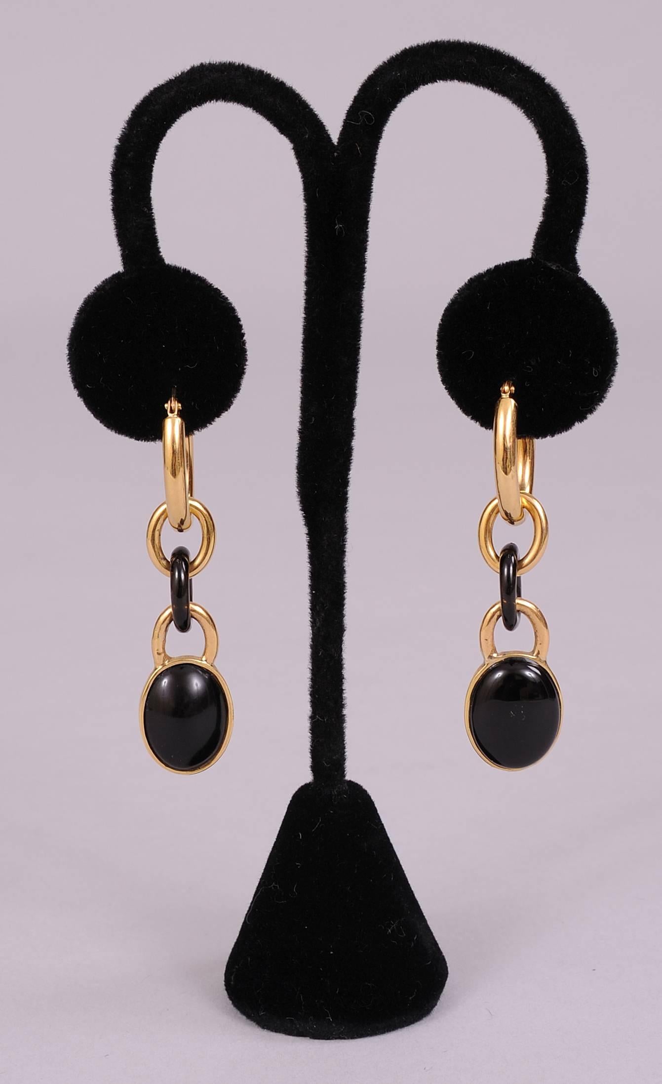 These chic earrings for pierced ears, have a large gold hoop at the top, and two smaller gold hoops with an onyx hoop in the middle . A large oval polished onyx stone is set in gold and suspended from the last hoop. The earrings are stamped Italy