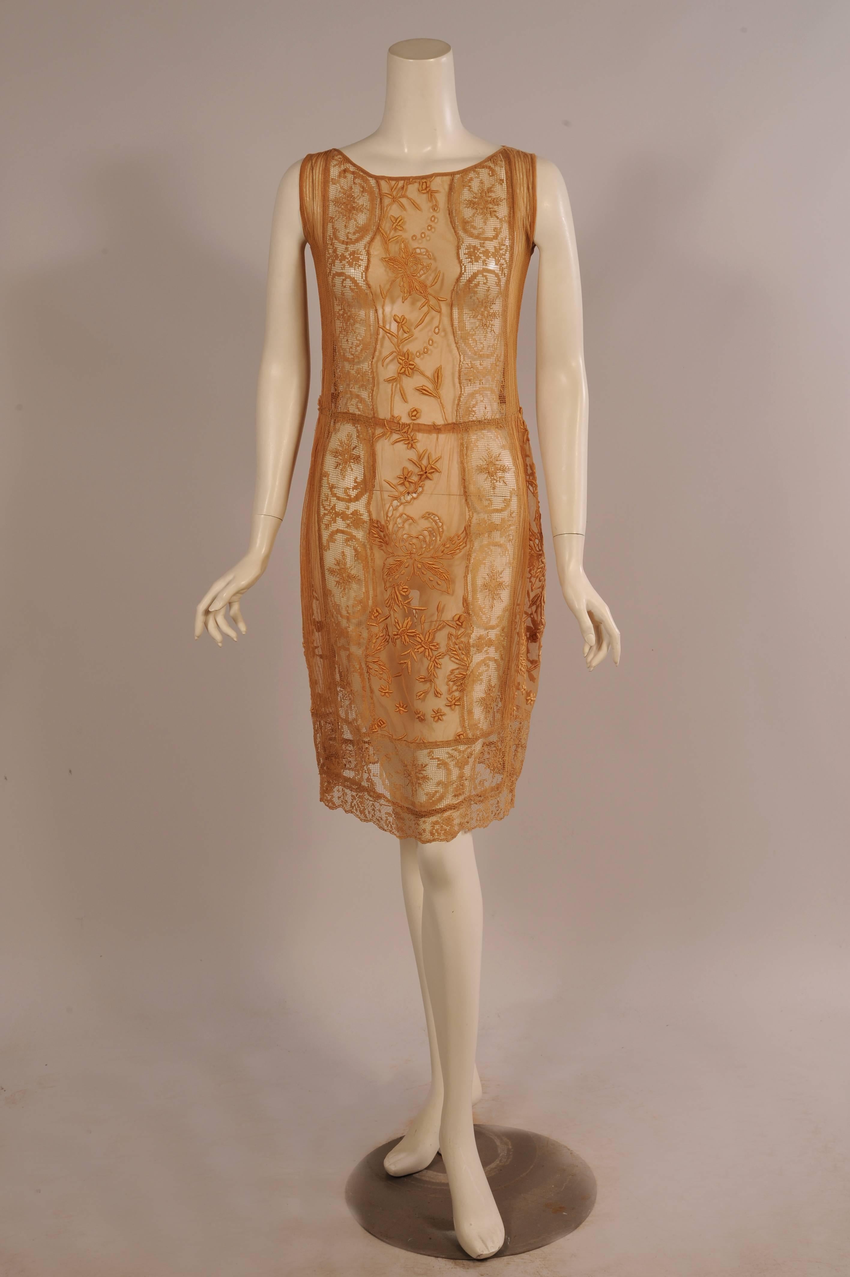 Hand embroidered panels, embroidered filet lace panels and pin tucked tulle panels are combined to make this lovely 1920's dress. The panels are sewn in a vertical design and they are finished with a horizontal panel at the hemline. This dress can